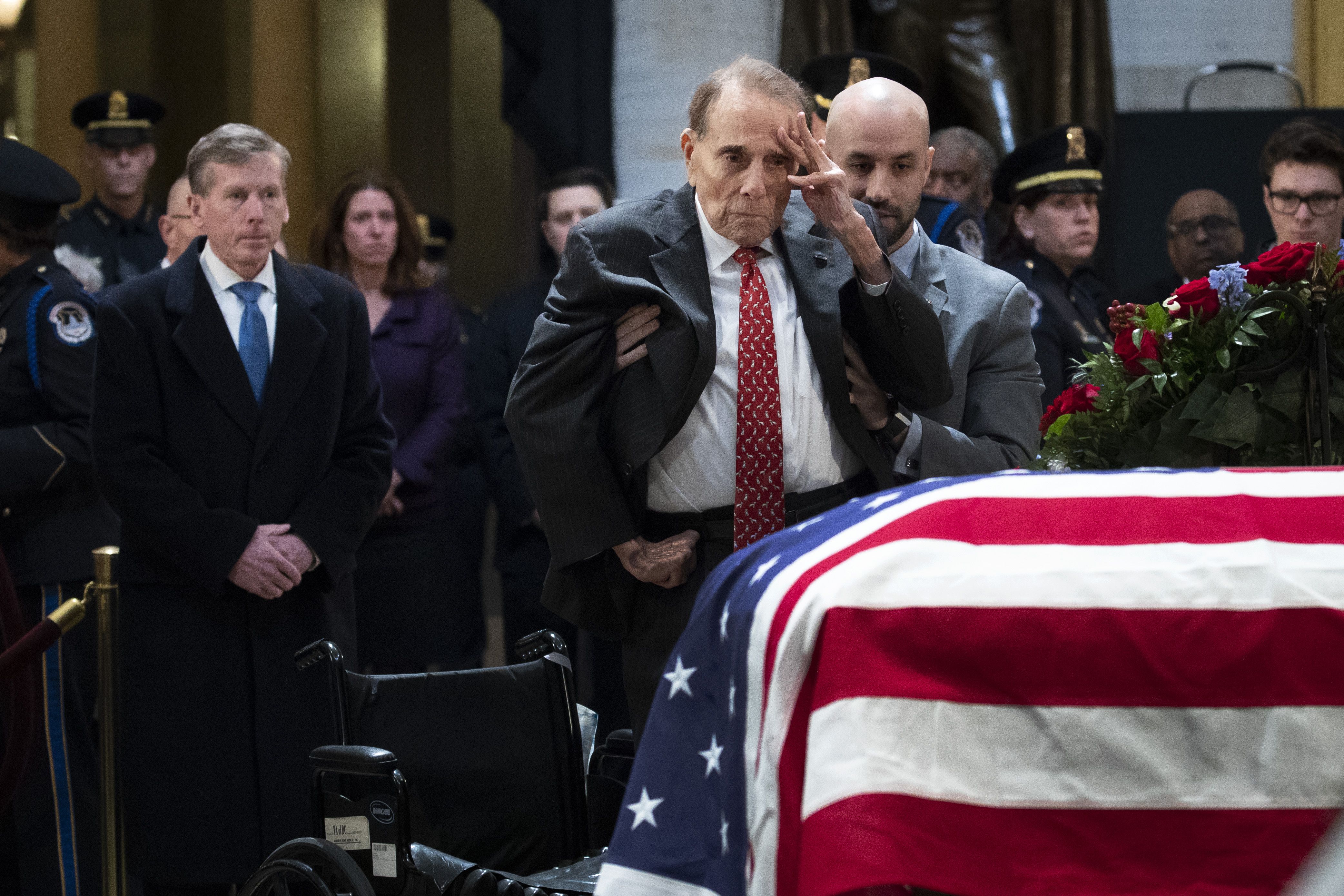 Bob Dole salutes the casket of the late former President George H.W. Bush in 2018