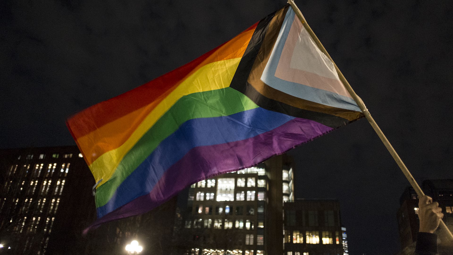 Photo of a person waving an LGBTQ pride flag