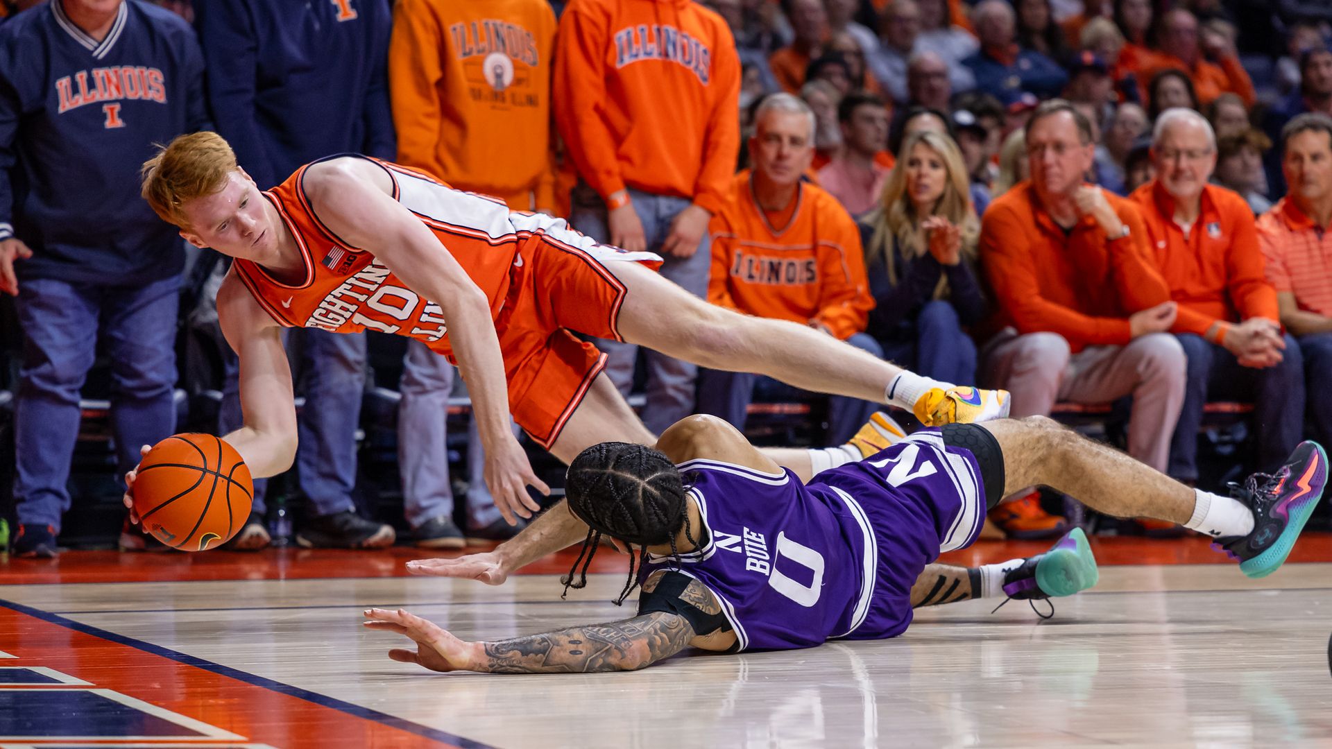 Luke Goode #10 of the Illinois Fighting Illini and Boo Buie #0 of the Northwestern Wildcats scramble for the ball at State Farm Center on January 2, 2024 in Champaign, Illinois.