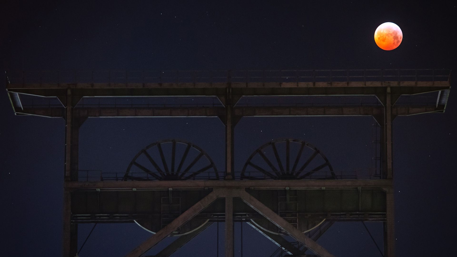 A Super Blood Moon is above a mineshaft in Dortmund, western Germany during a lunar eclipse