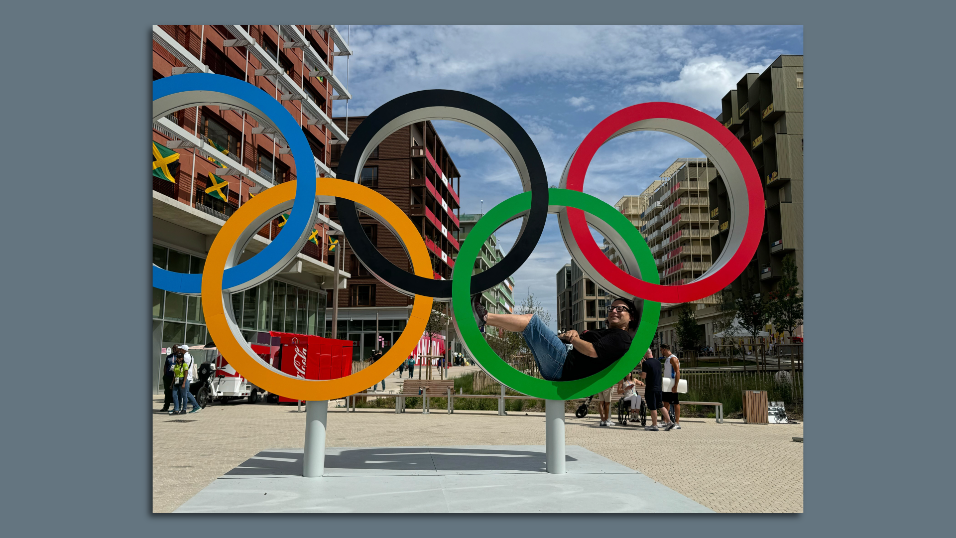 Ina Friend laying inside the green ring of the Olympic Rings in Olympic Village