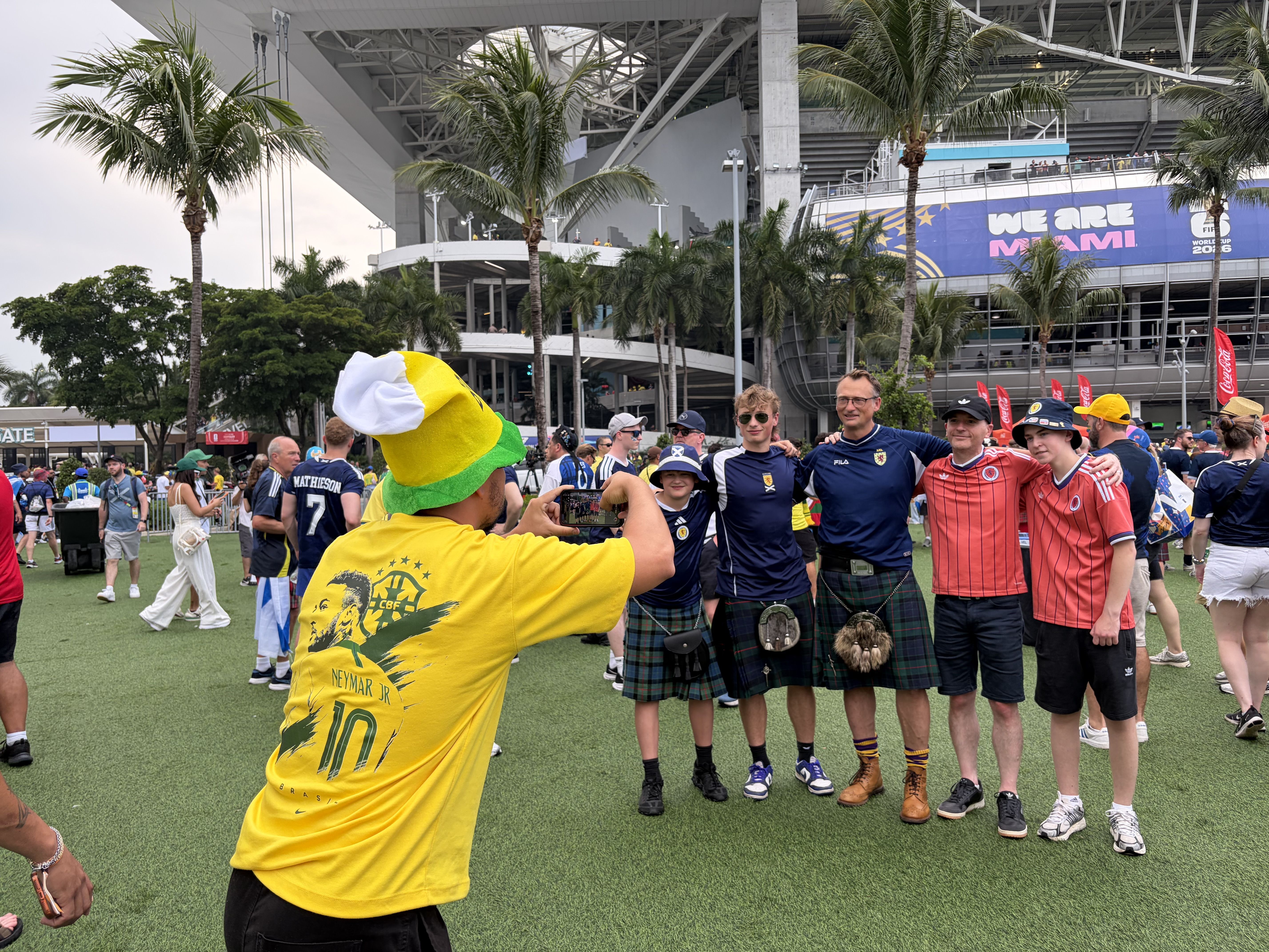 A Brazlian fan takes a photo for a Scottish group.