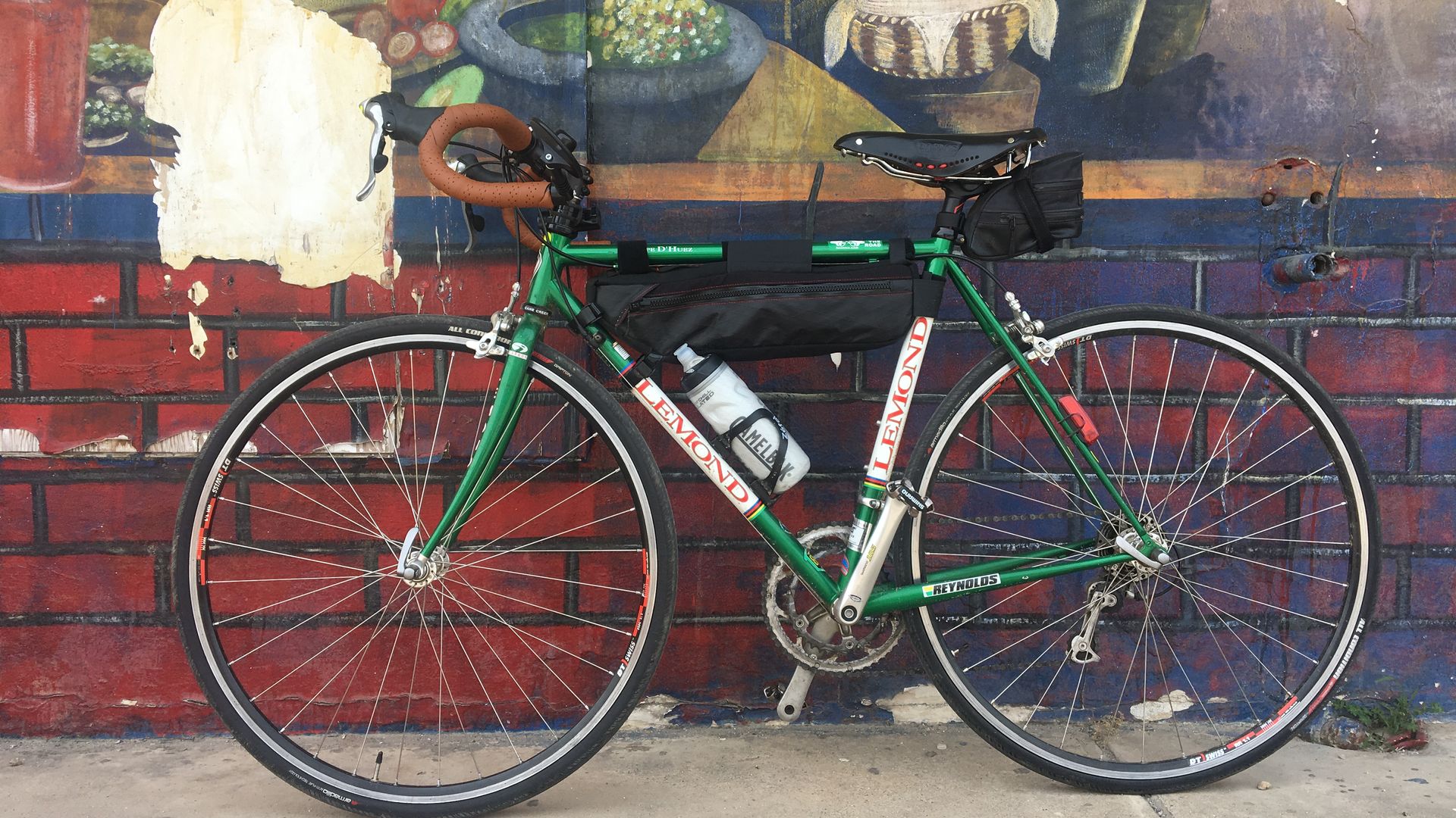 Bike leans against a mural wall
