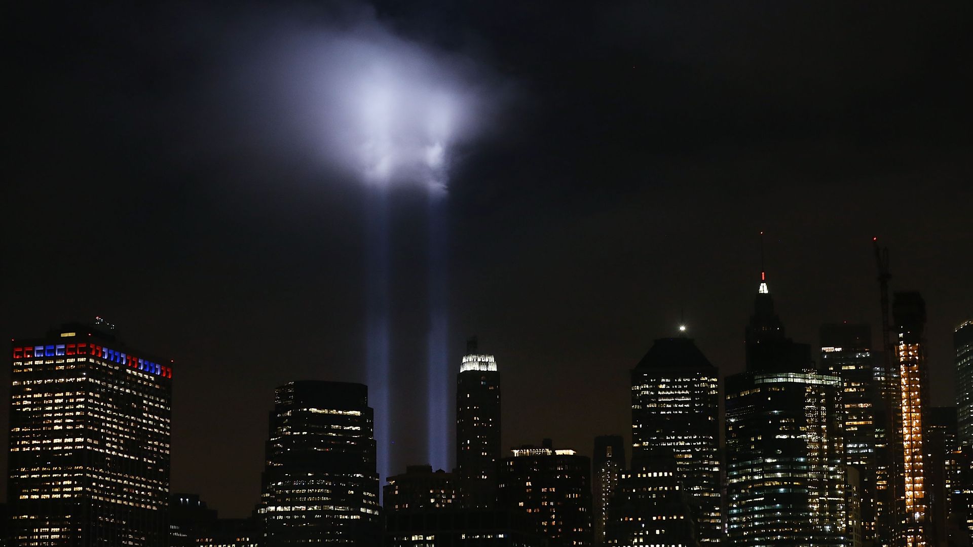 Twin towers' absence highlighted with spotlights in the night sky.