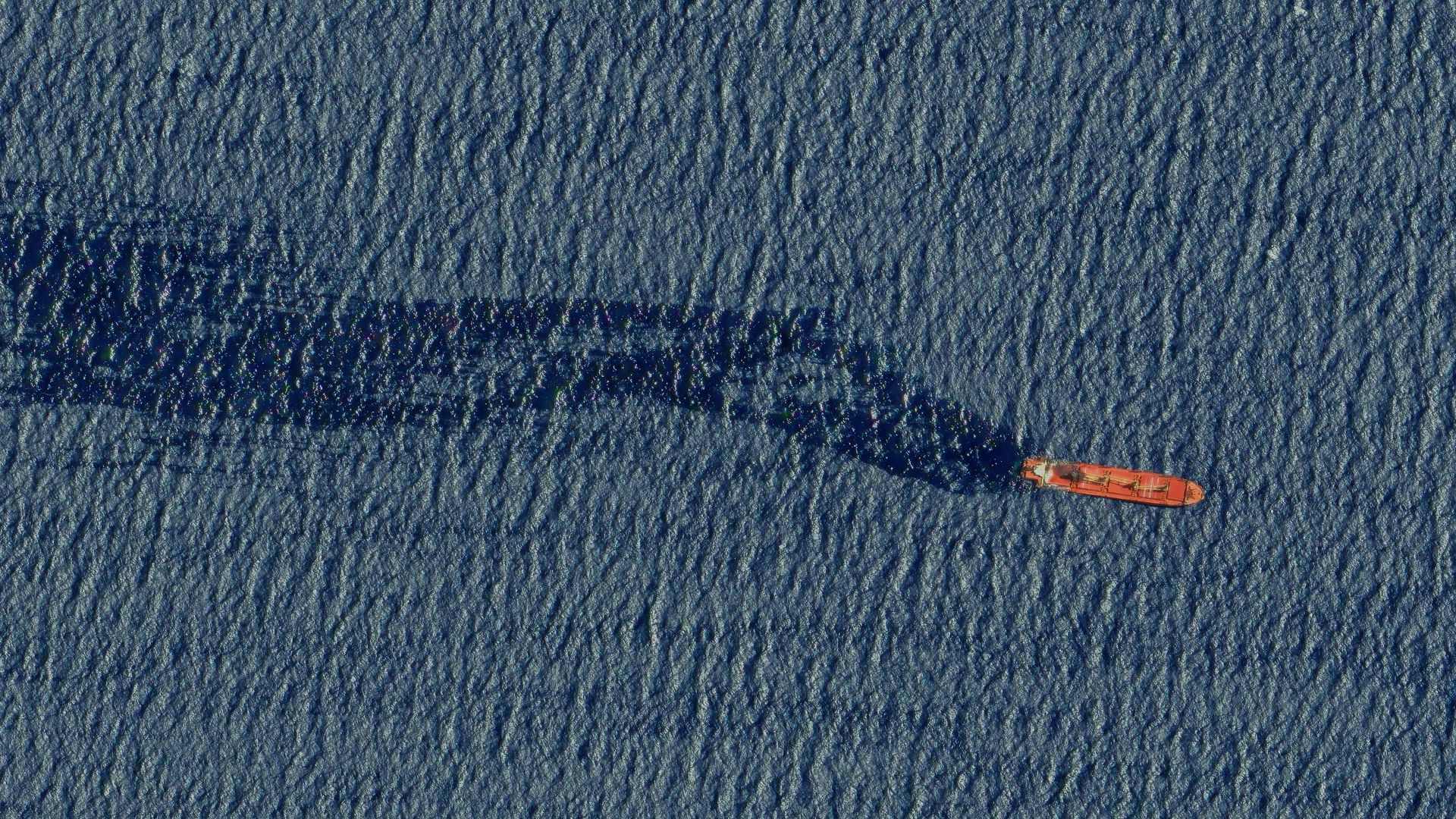A top down view of the Rubymar ship, red in color, moving through blue waters before it sank following Houthi attack.