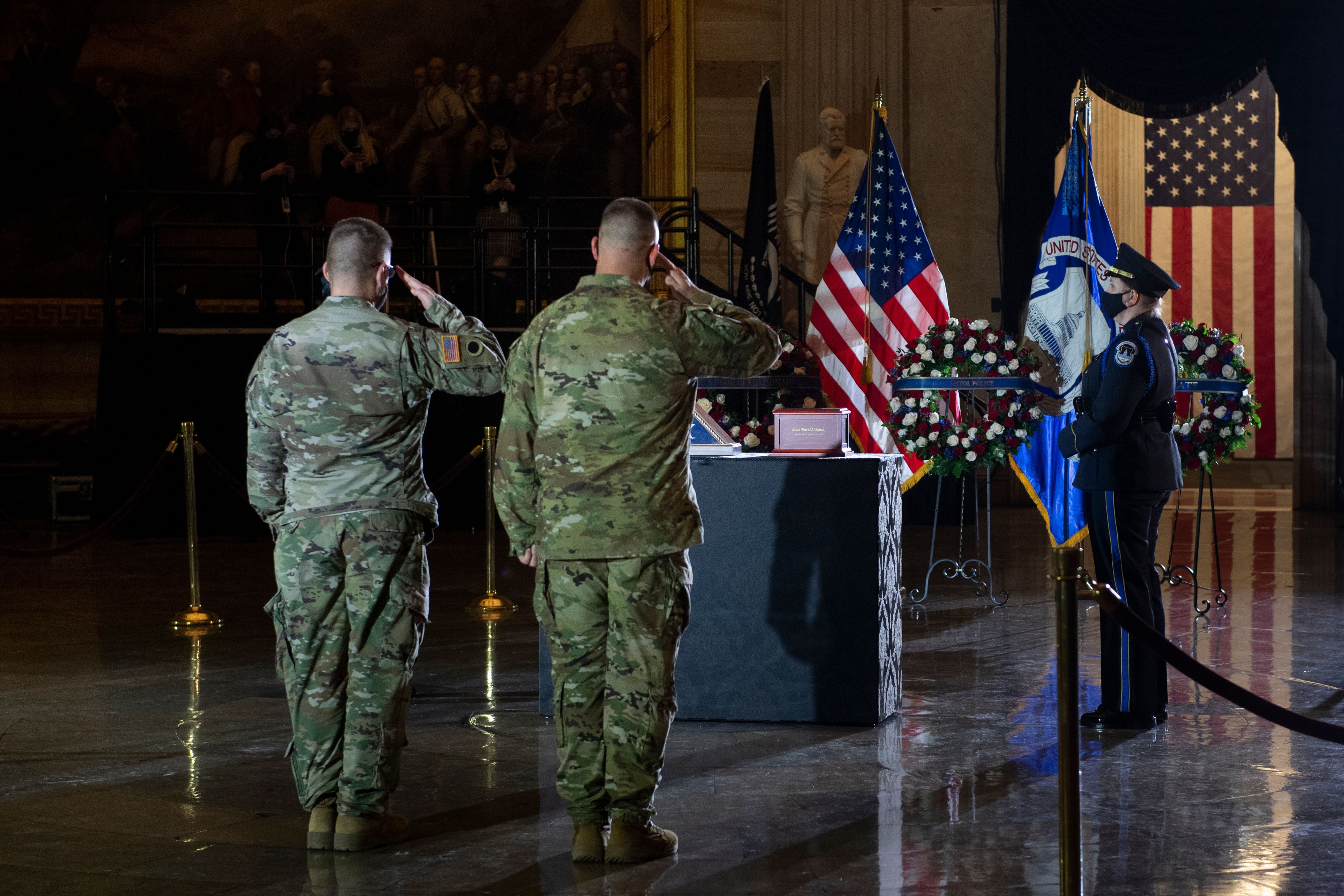 Members of the National Guard salute as they pay their respects late US Capitol Police officer Brian Sicknick as he lies in honor in the US Capitol Rotunda