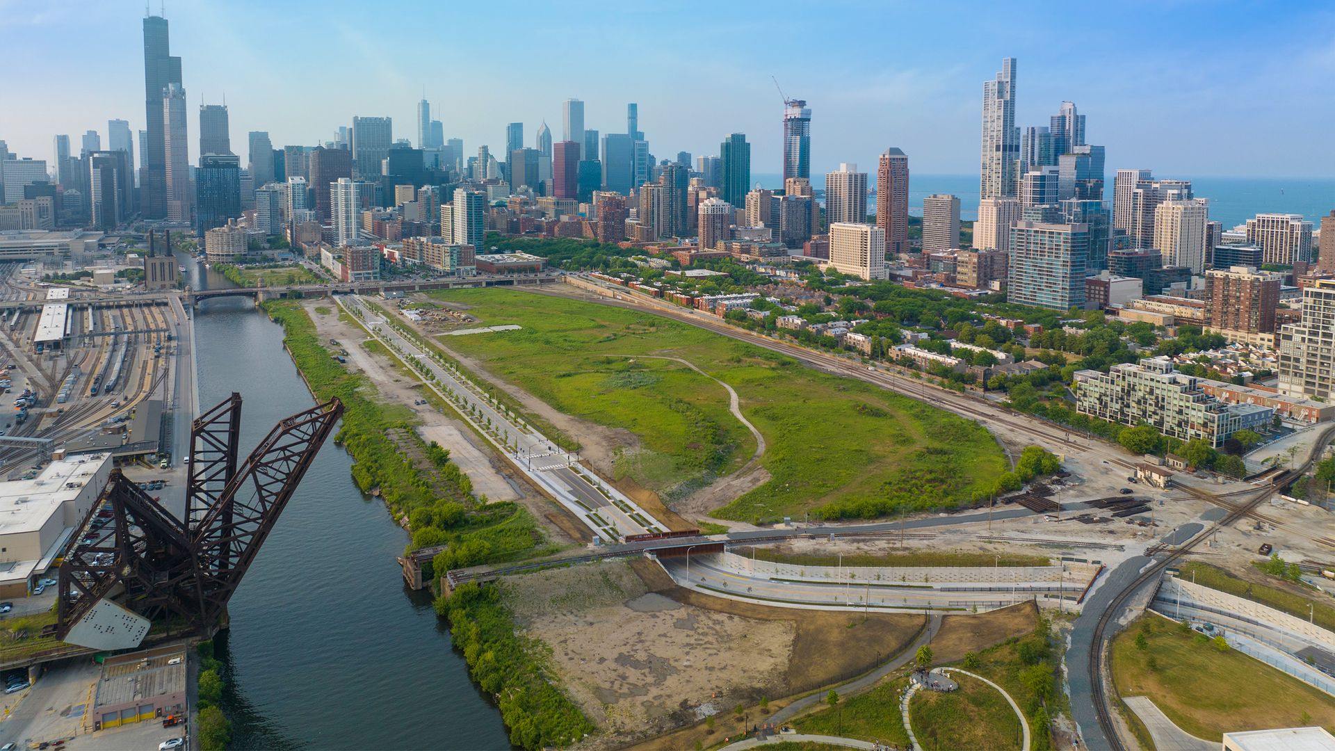 Aerial view of Chicago skyline with grass, streets and river.