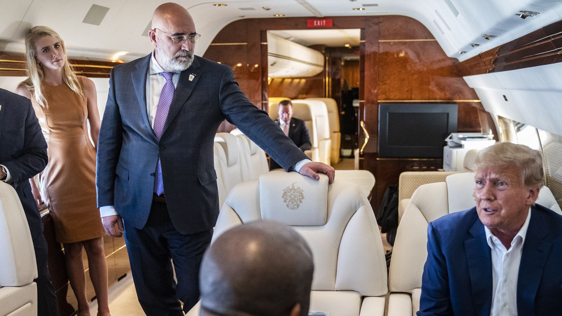 alt Nauta, aid to former President Donald Trump, left, and Chris LaCivita, center, listen as former President Donald Trump speaks with reporters and staff on his airplane, known as Trump Force One, as he is flown to Iowa on Monday, March 13, 2023, in West Palm Beach, FL. 