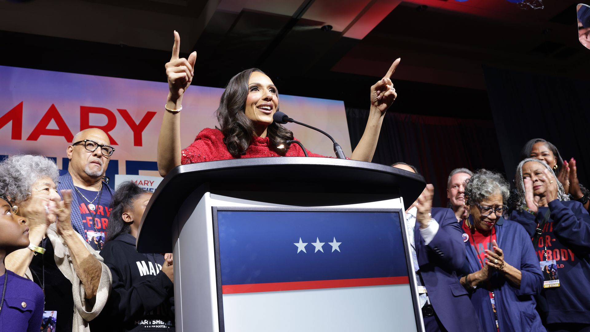 Sheffield speaks from a decorated stage with family and supporters clapping behind her