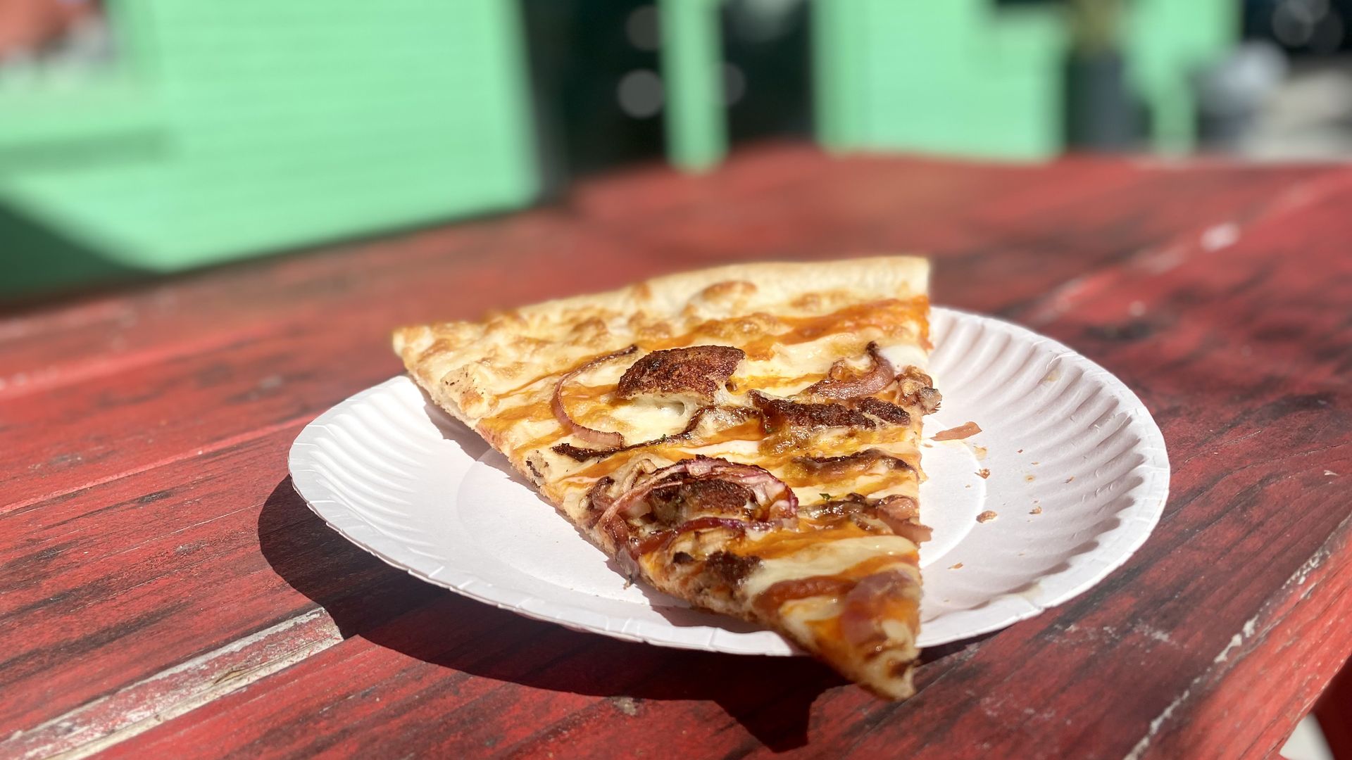 A slice of pizza on a picnic table.