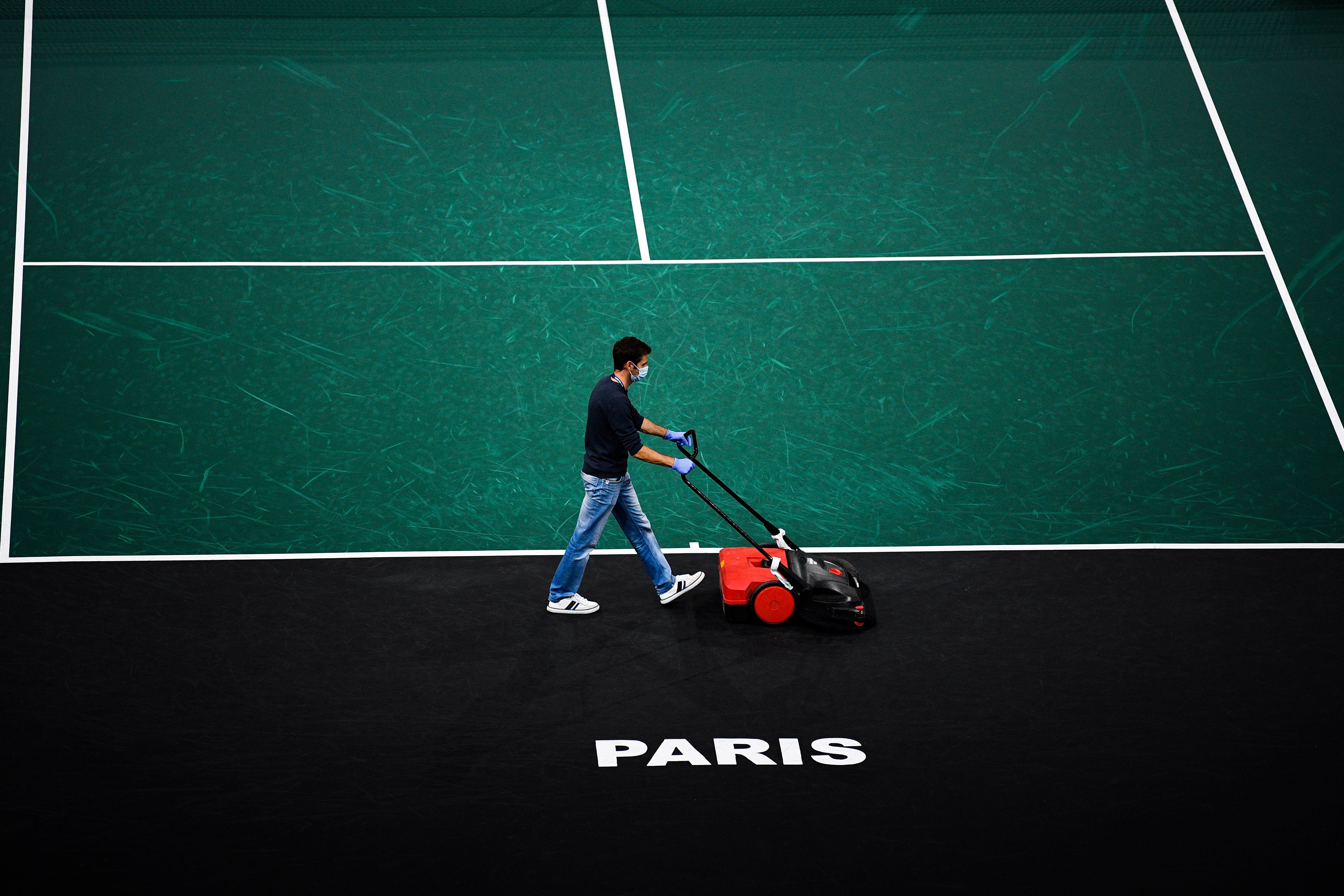 Person cleaning tennis court