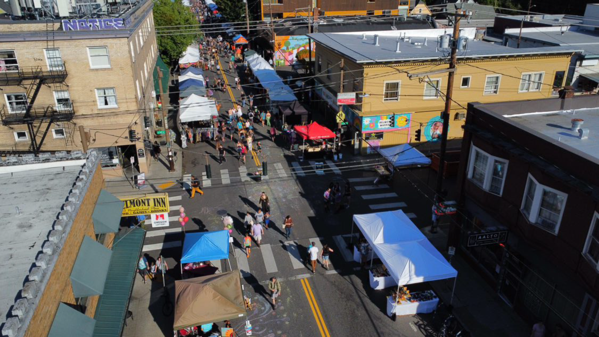 Three blocs of a street fair from the air with a few dozen people walking
