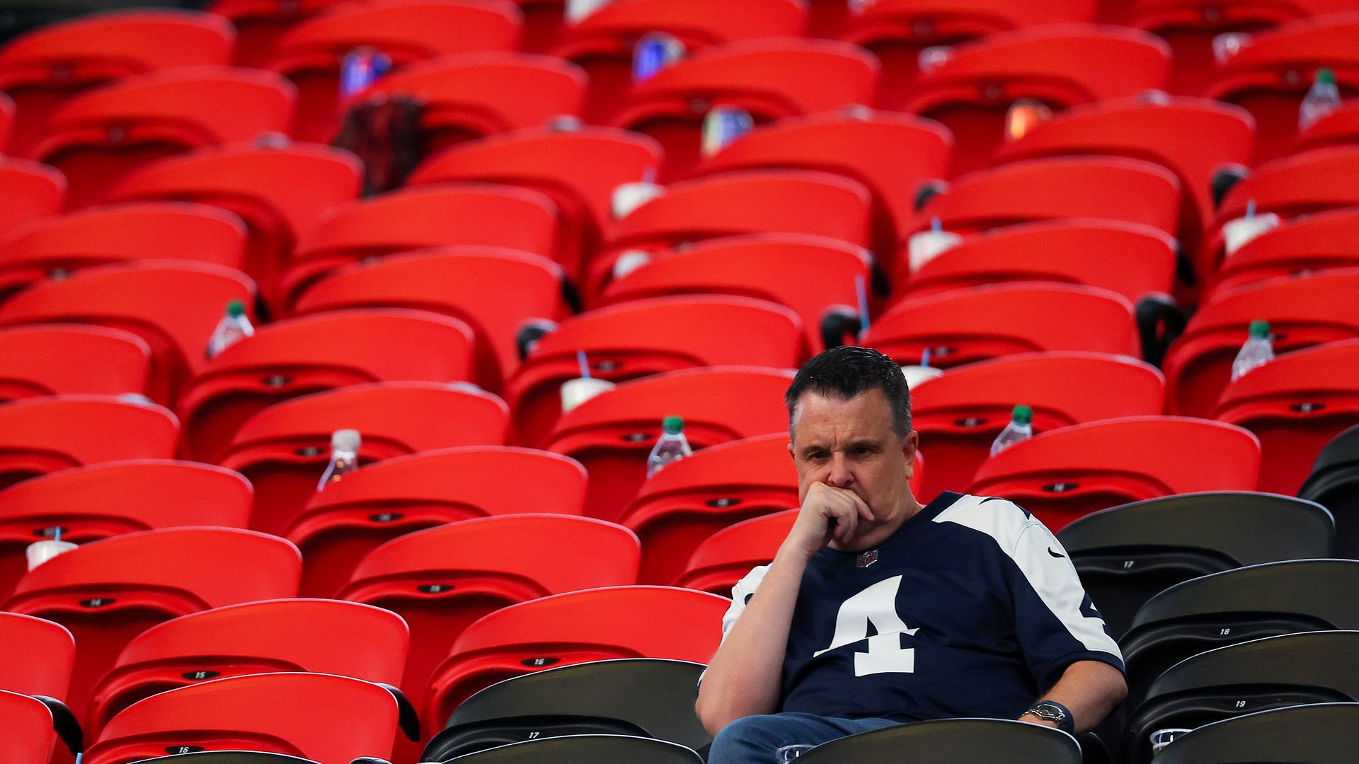 A very sad and lonely Cowboys fan sits alone in the seats in Atlanta