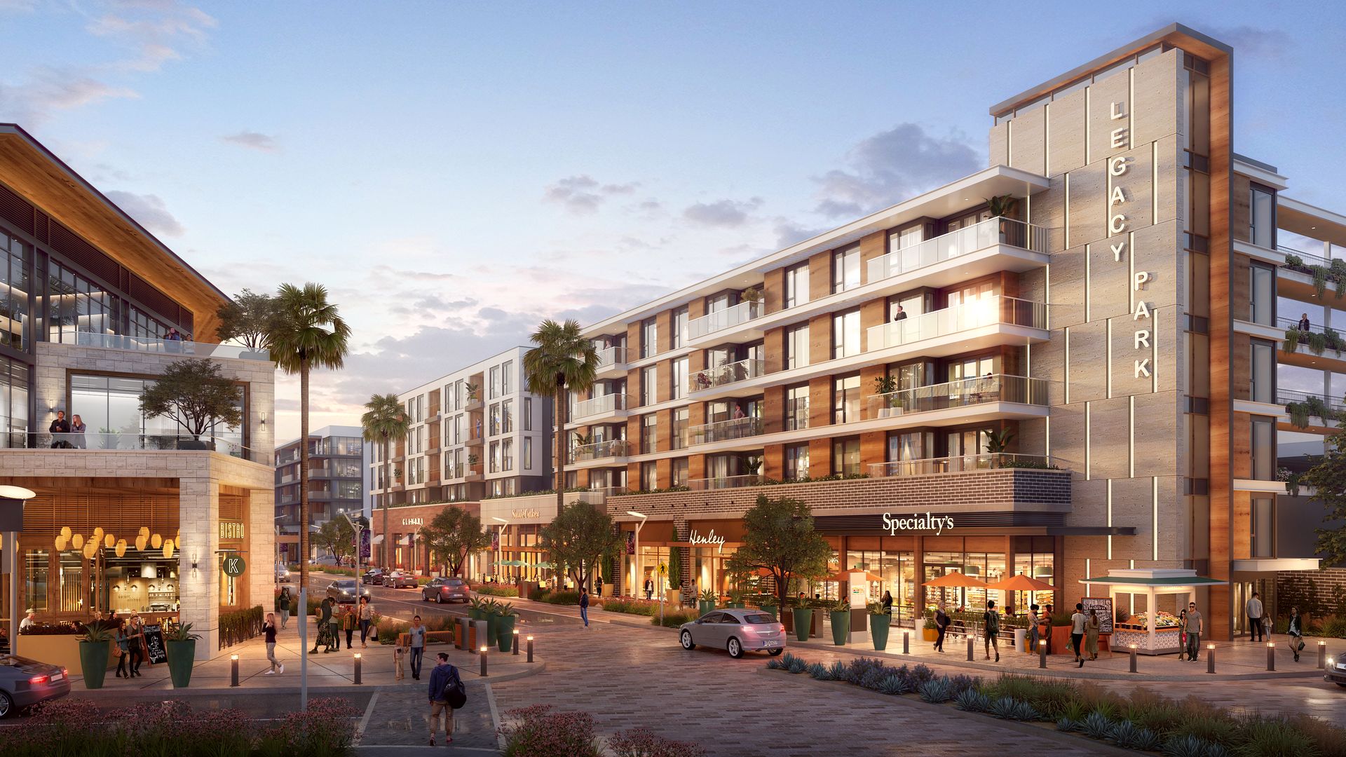 Modern mixed-use complex at dusk: brick-and-glass building with vertical "LEGACY PARK" signage, balconies, palm trees, street shops, outdoor seating, pedestrians, and cars.