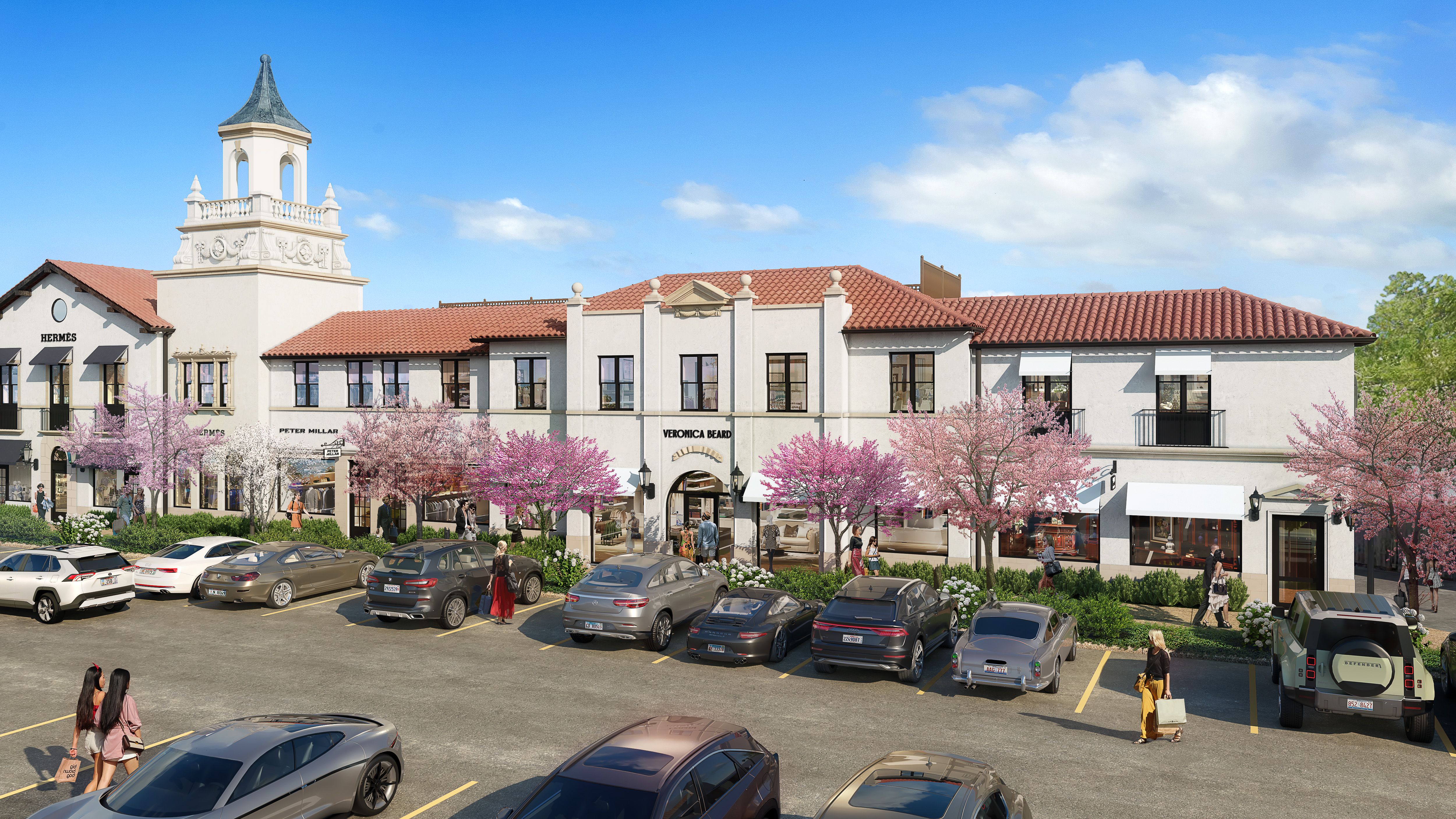 White stucco mall with red roof and parking lot.