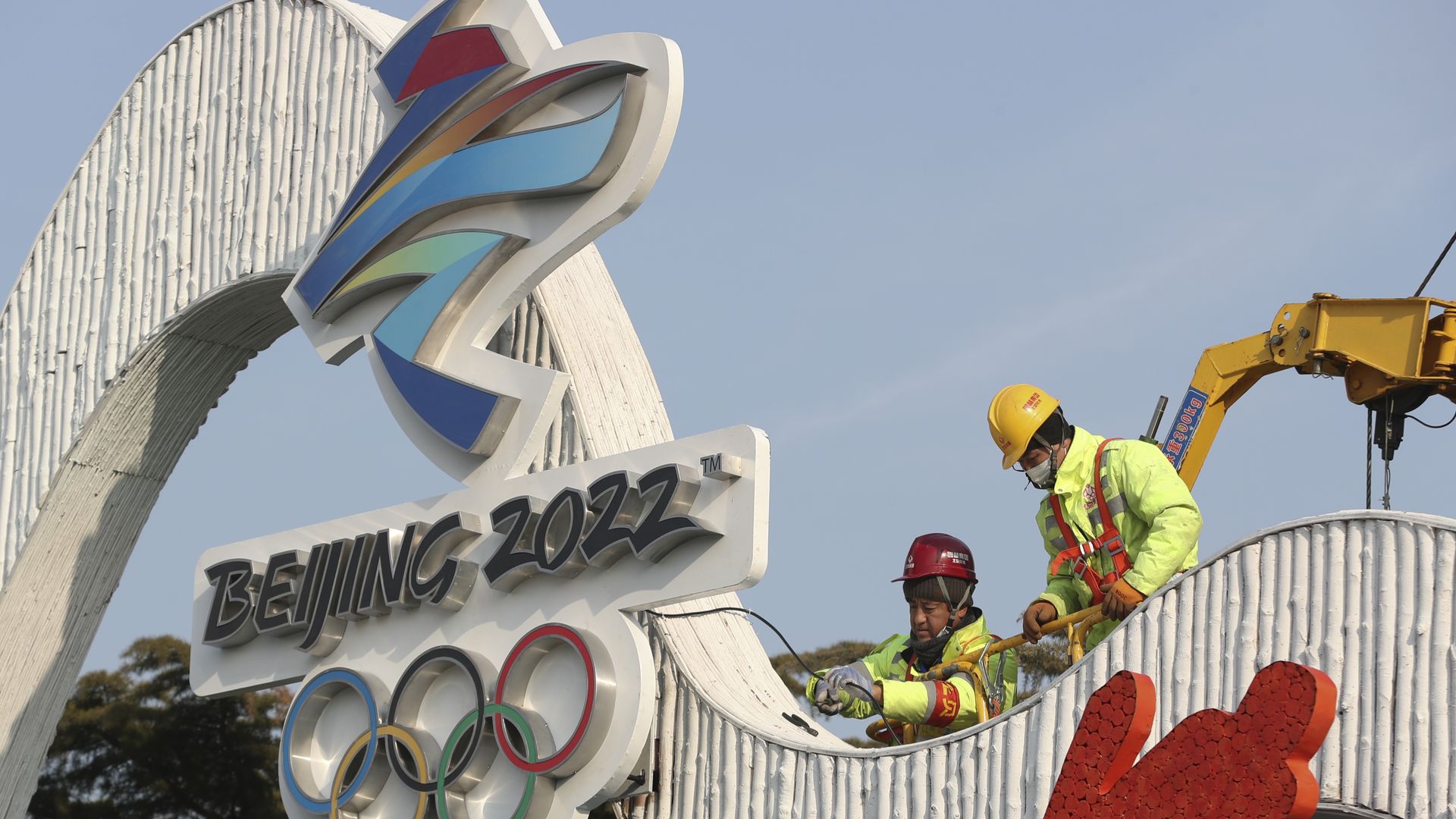 Workers installing a Winter Olympics-themed sign in Beijing on Jan. 14.
