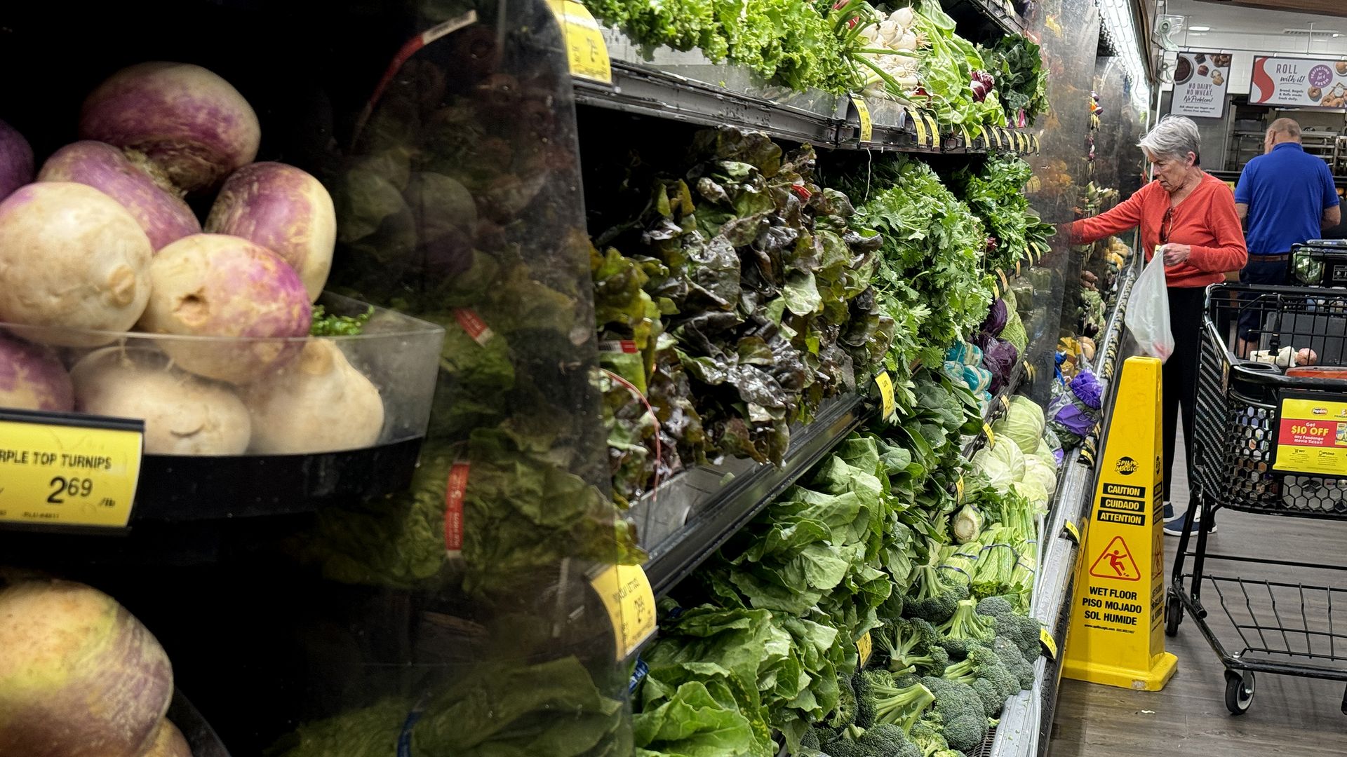 Shoppers in the vegetable aisle of the grocery store