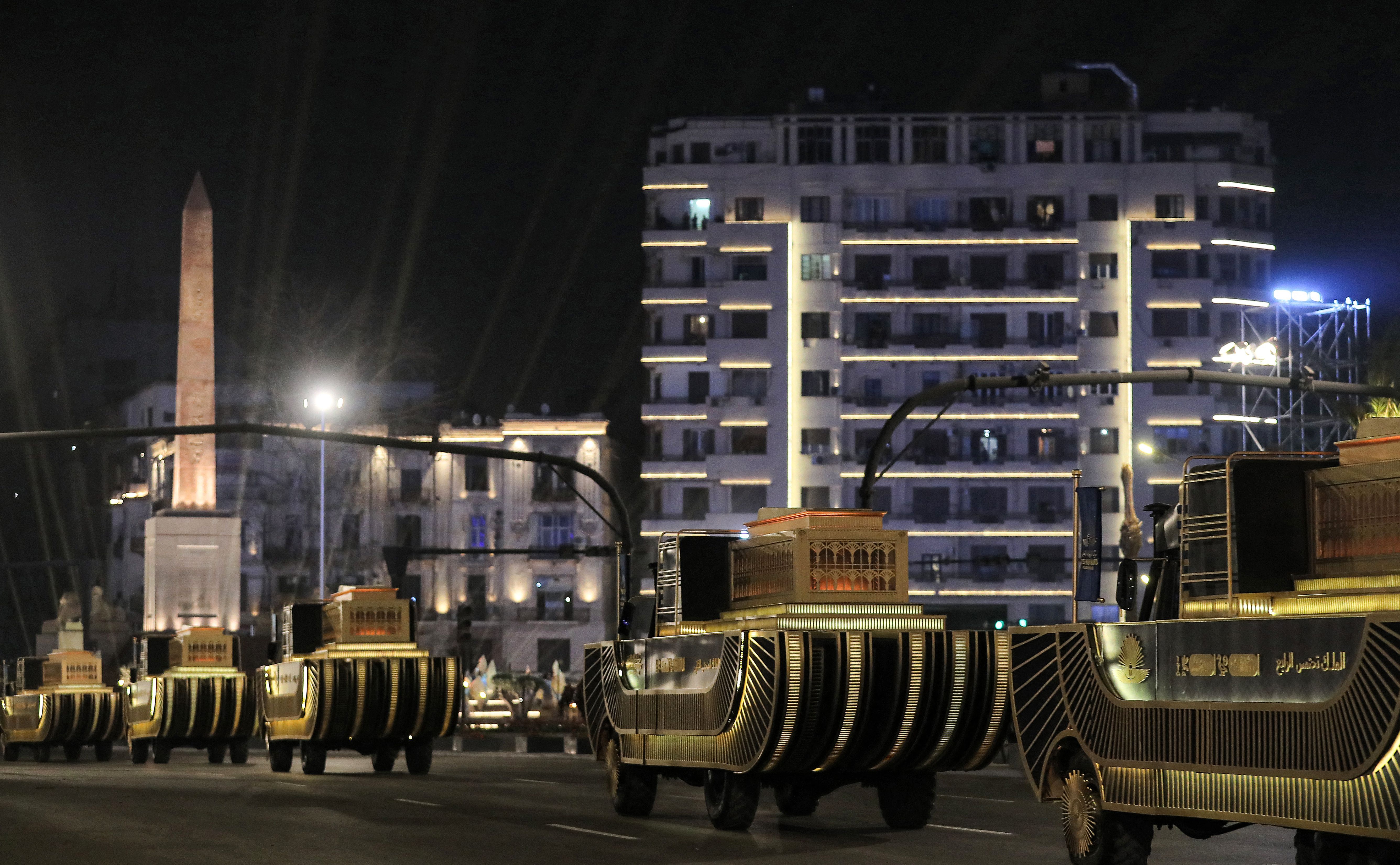 The carriages carrying 22 ancient Egyptian royal mummies advance along the roundabout of Tahrir Square containing the Obelisk of Ramses II 