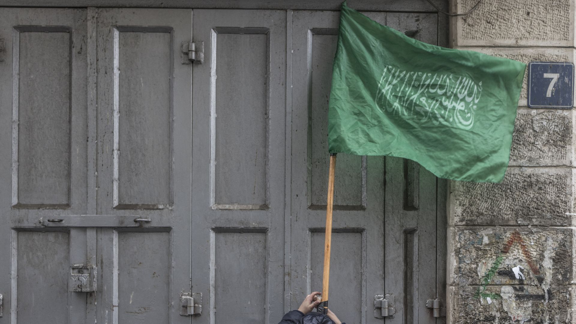 A child tapes a stick holding a Hamas flag during a demonstration in support of the Palestinian resistance in Al-Manara Square in the West Bank city of Ramallah, on Jan.12, 2024. 