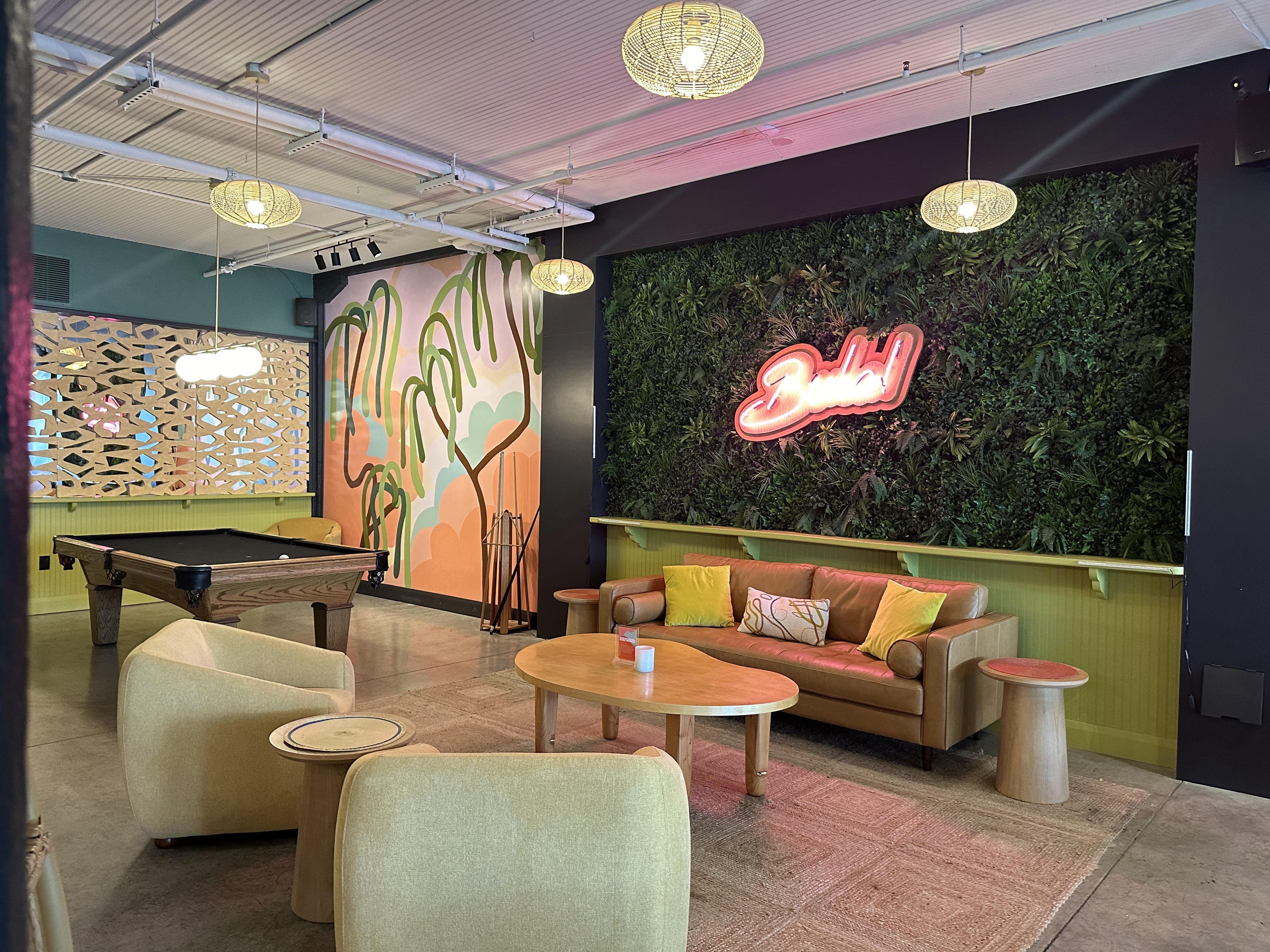 a cool looking room with lounge chairs and a bush wall