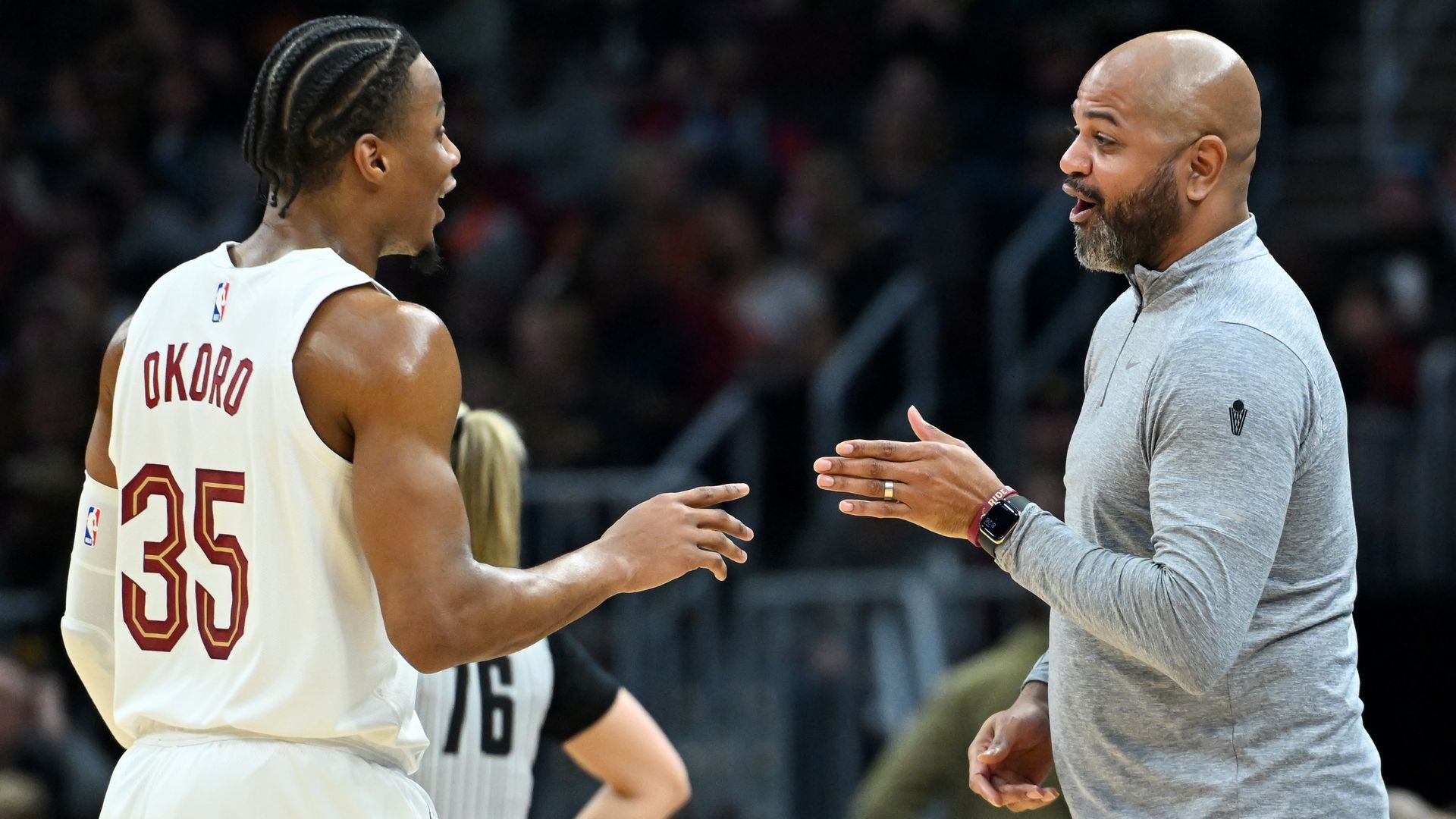 Cavs coach JB Bickerstaff gestures to player Isaac Okoro (in white jersey)