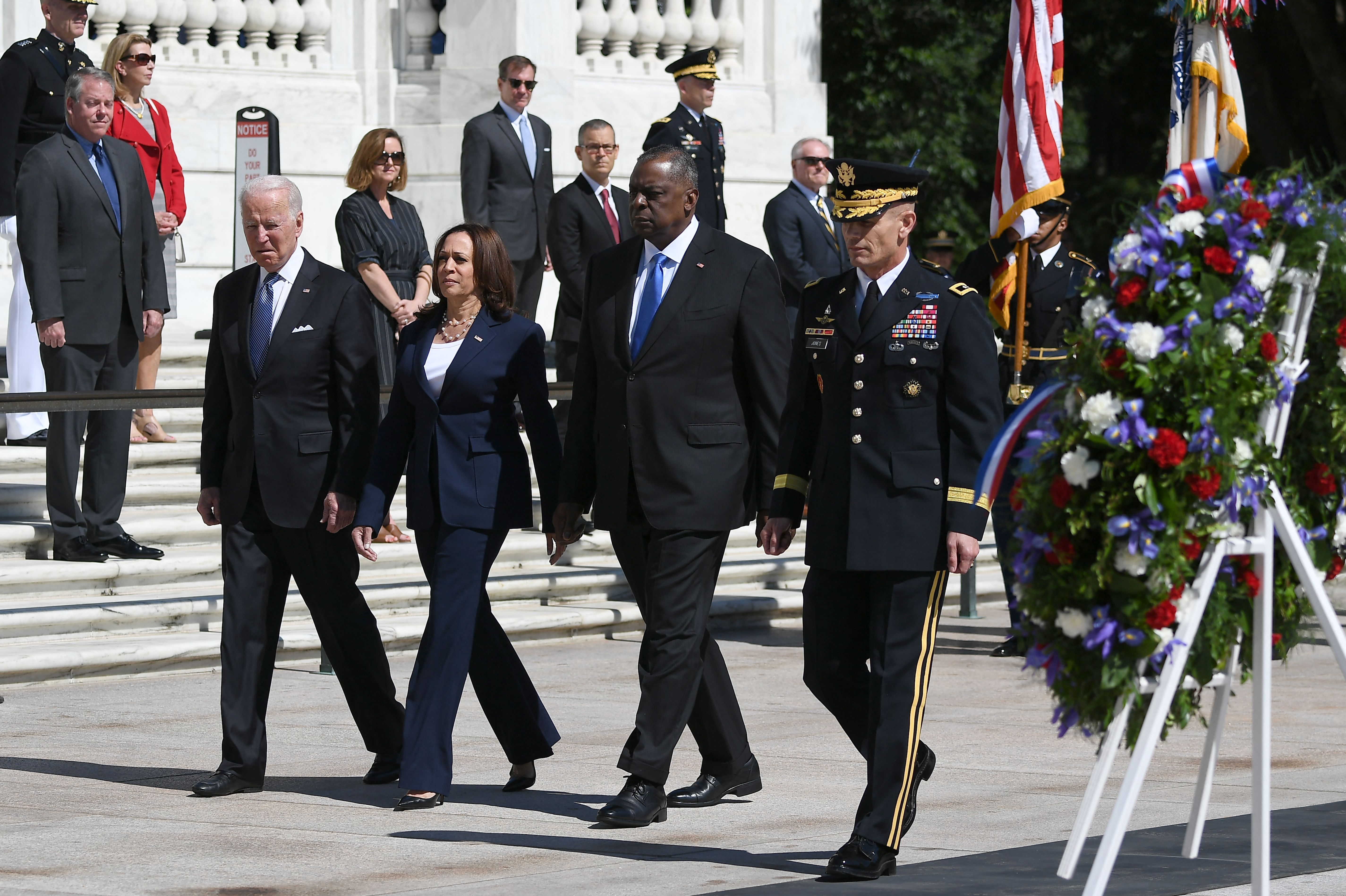 Biden, VP Kamala Harris, Defense Secretary Lloyd Austin walk in a line in front of wreaths and American flags