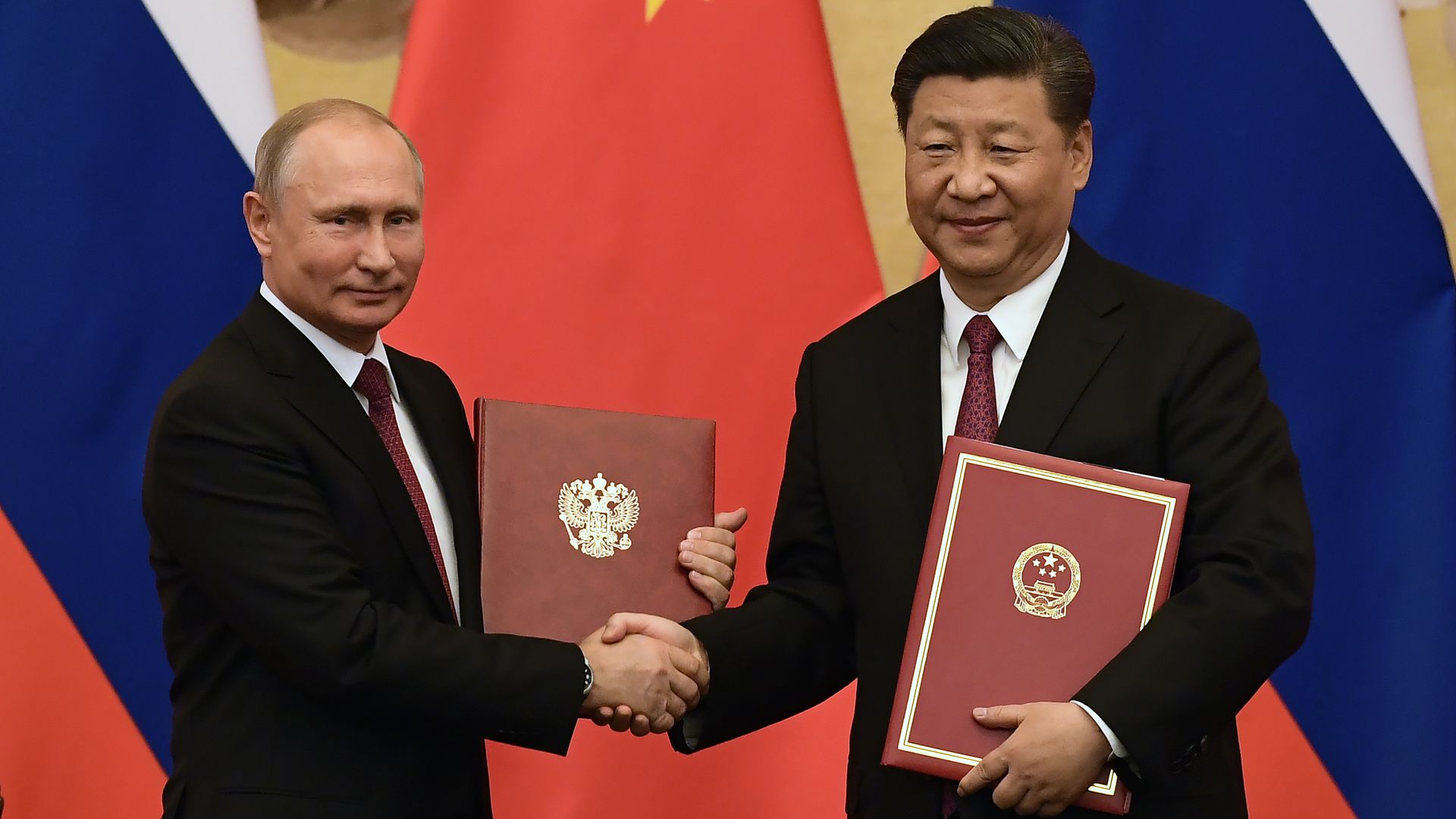 Russian President Putin shaking Chinese President Xi and getting friendship award