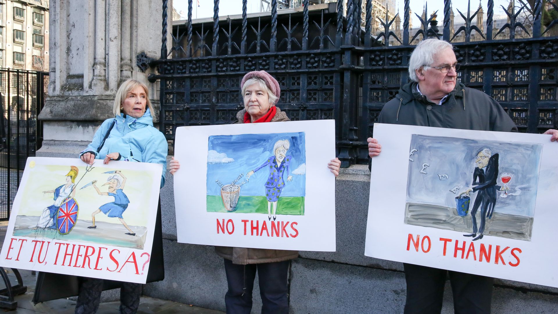 Pro Brexit campaigners standing with signs outside the Houses of Parliament