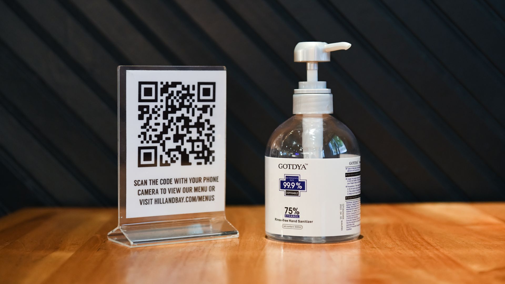 QR code for menus on display, next to bottle of hand sanitizer 