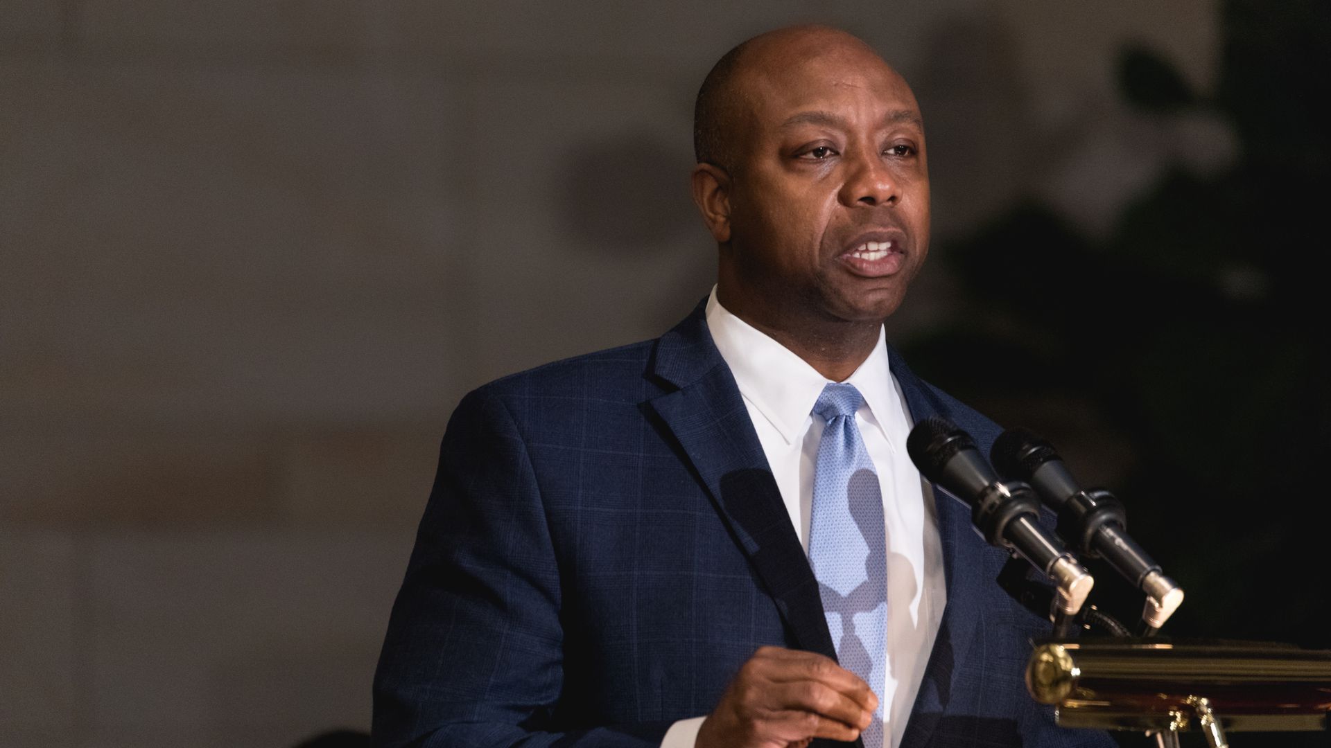 Sen. Tim Scott speaks at a podium which holds two microphones