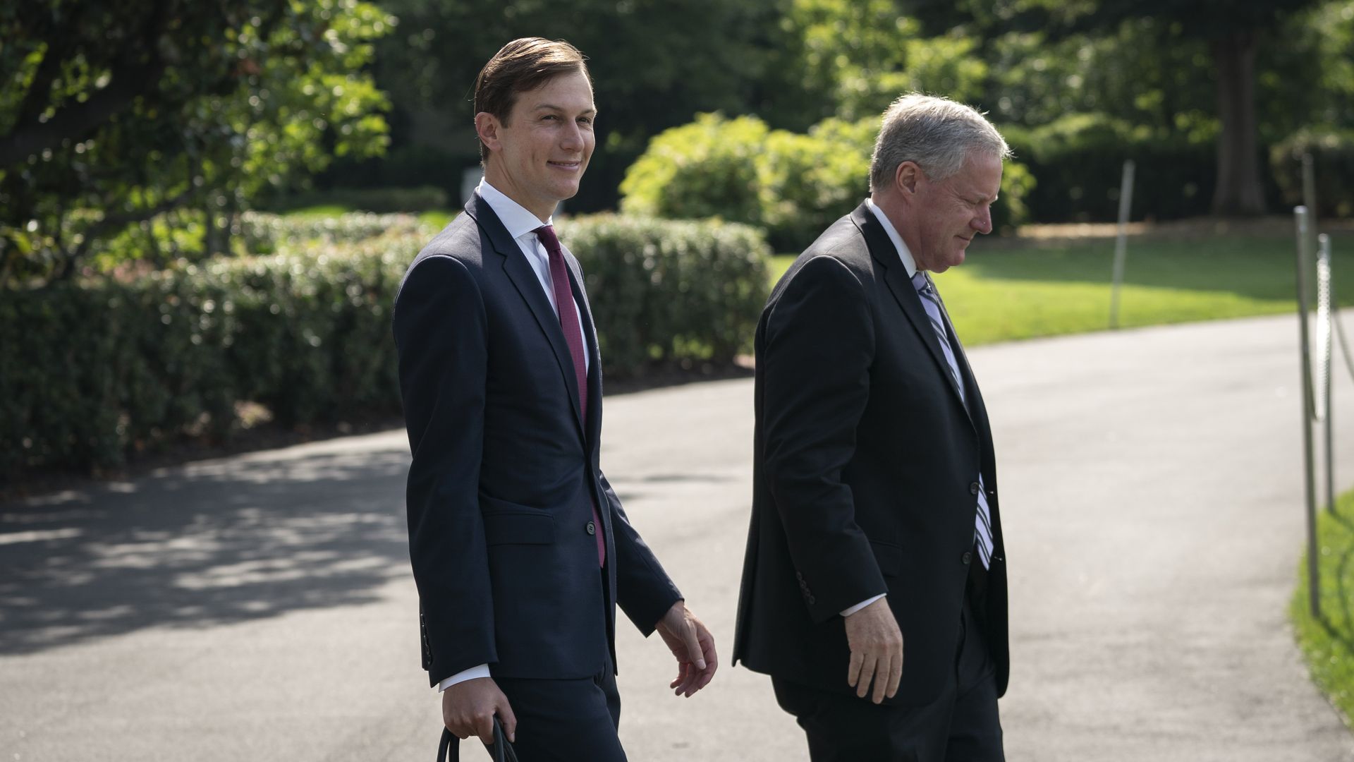 Jared Kushner and Mark Meadows walk across the White House lawn