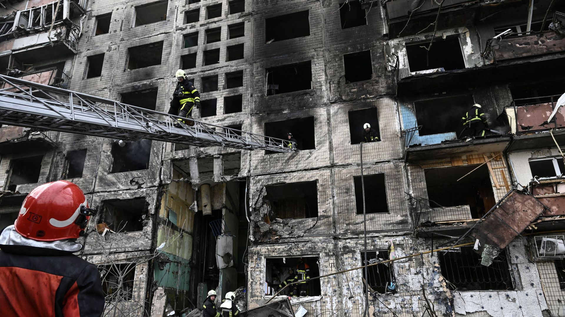 Firefighters carry out a check and rescue search after an apartment building was shelled in the northwestern Obolon district of Kyiv on March 14.