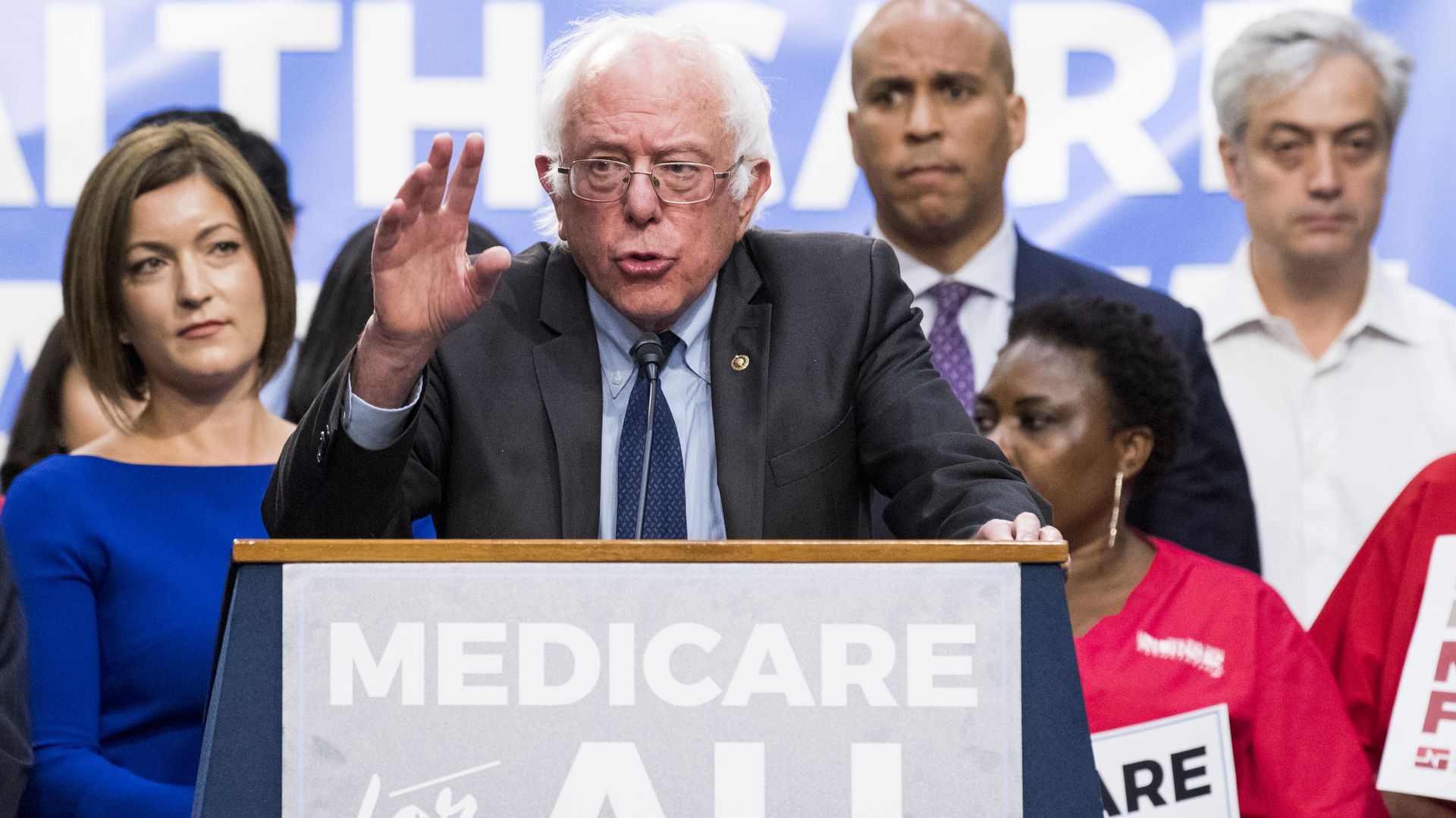 Bernie Sanders speaking behind a Medicare for All lectern