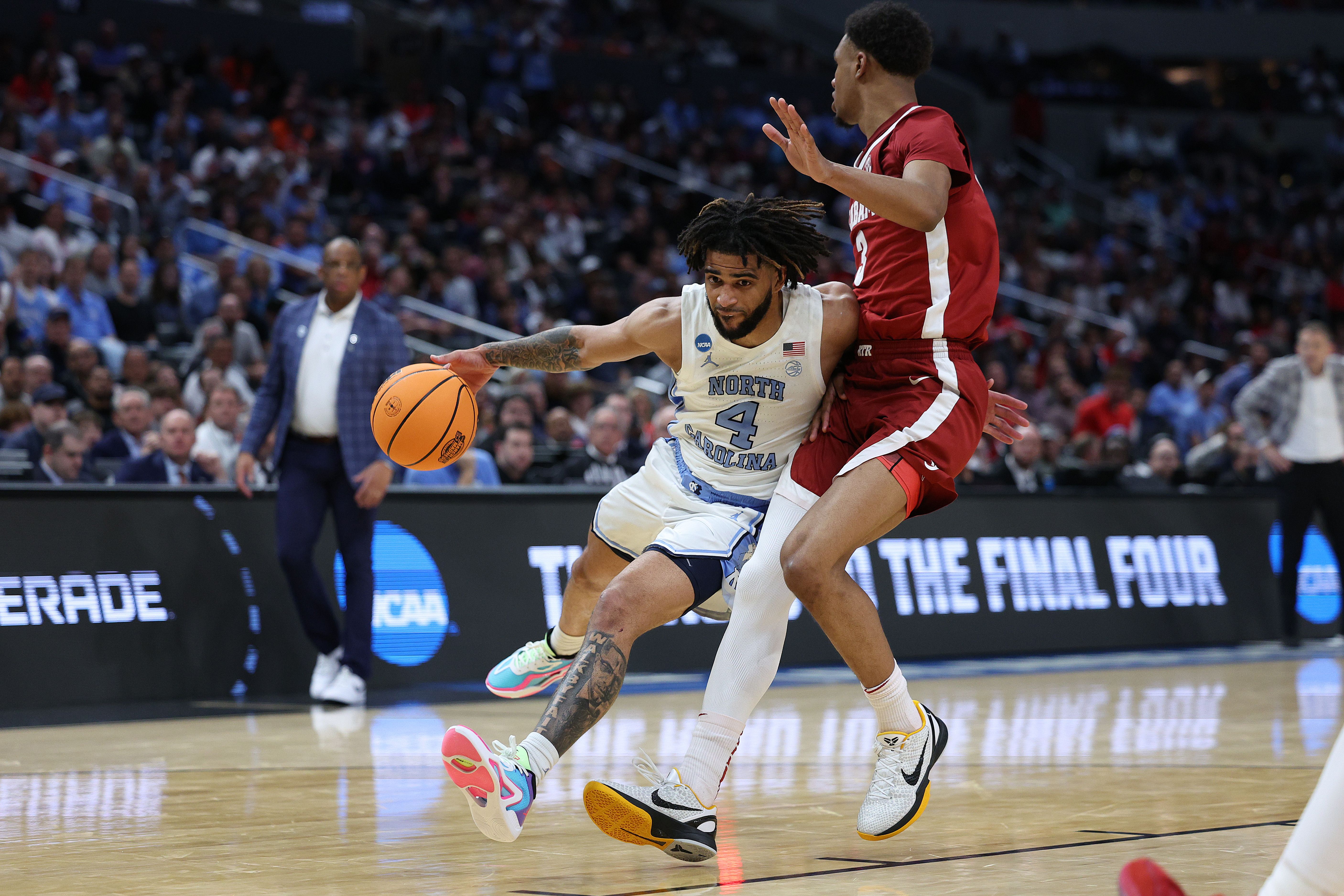 LOS ANGELES, CALIFORNIA - MARCH 28: RJ Davis #4 of the North Carolina Tar Heels is fouled by Rylan Griffen #3 of the Alabama Crimson Tide as he drives during the second half in the Sweet 16 round of the NCAA Men's Basketball Tournament at Crypto.com Arena on March 28, 2024 in Los Angeles, California