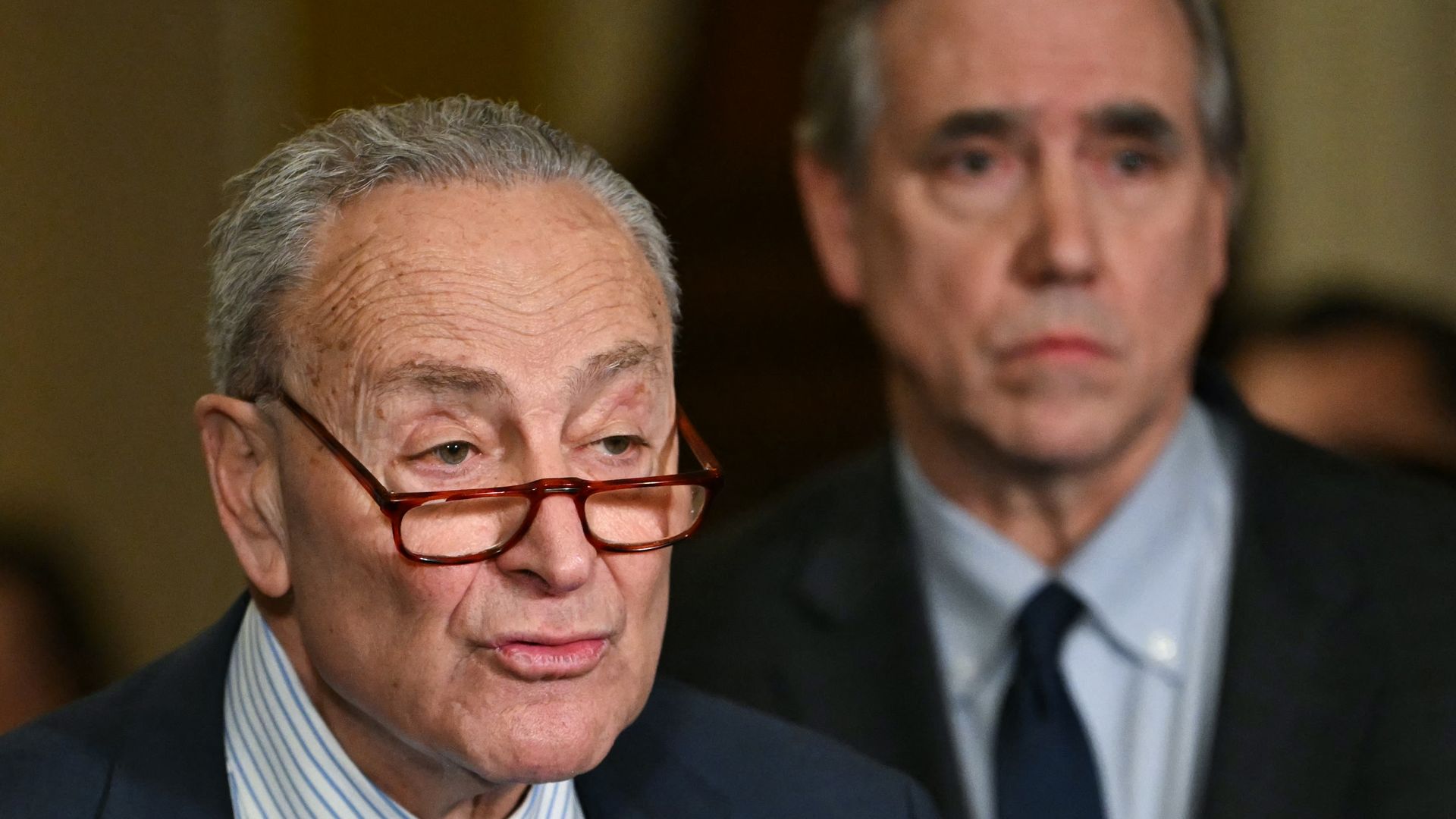 US Senate Minority Leader Chuck Schumer (L), Democrat from New York, speaks to reporters as Senator Jeff Merkley, Democrat from Oregon, looks on following the weekly Senate Democrats policy luncheon, at the US Capitol in Washington, DC on January 28, 2025