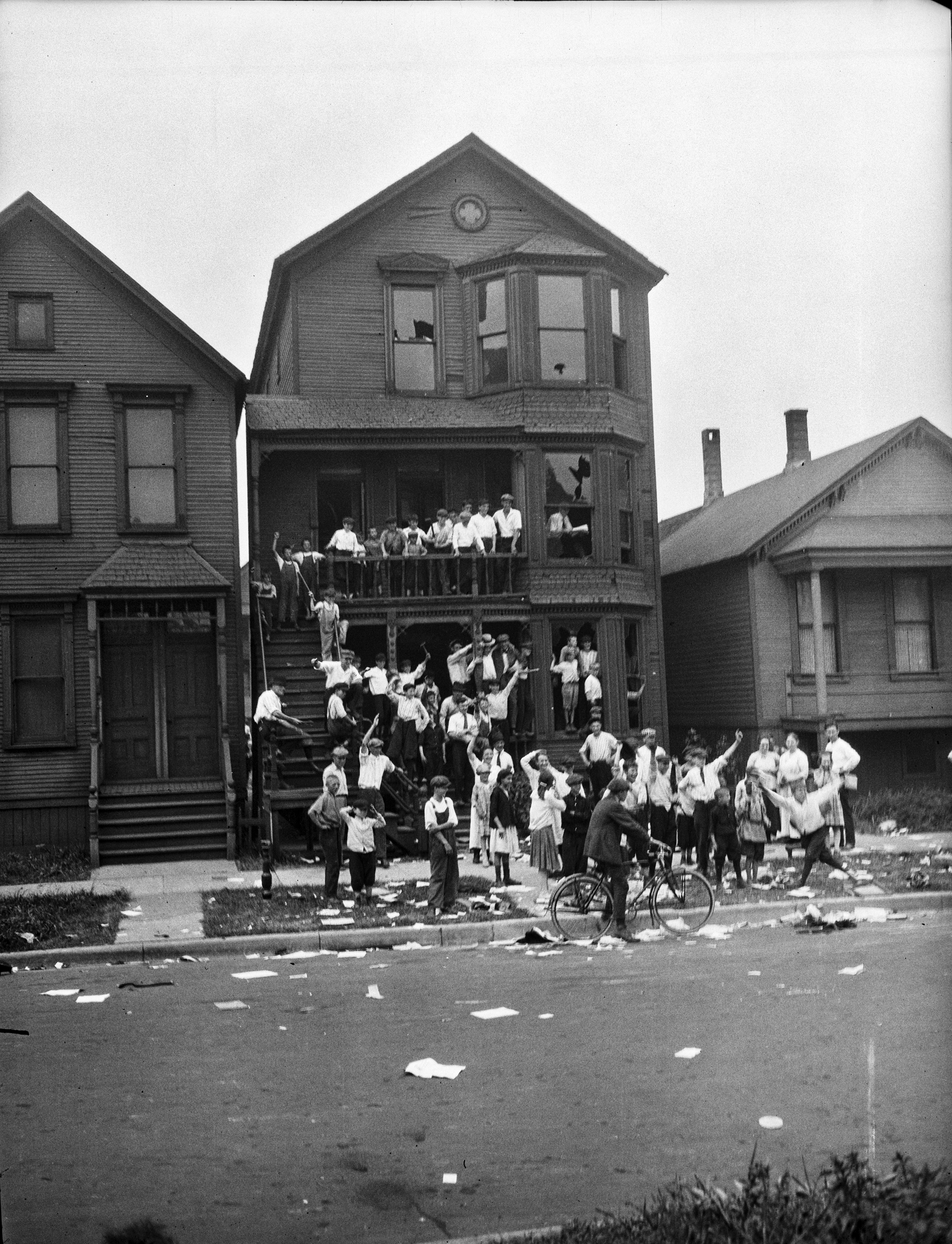 Photo of people surronding a house. 