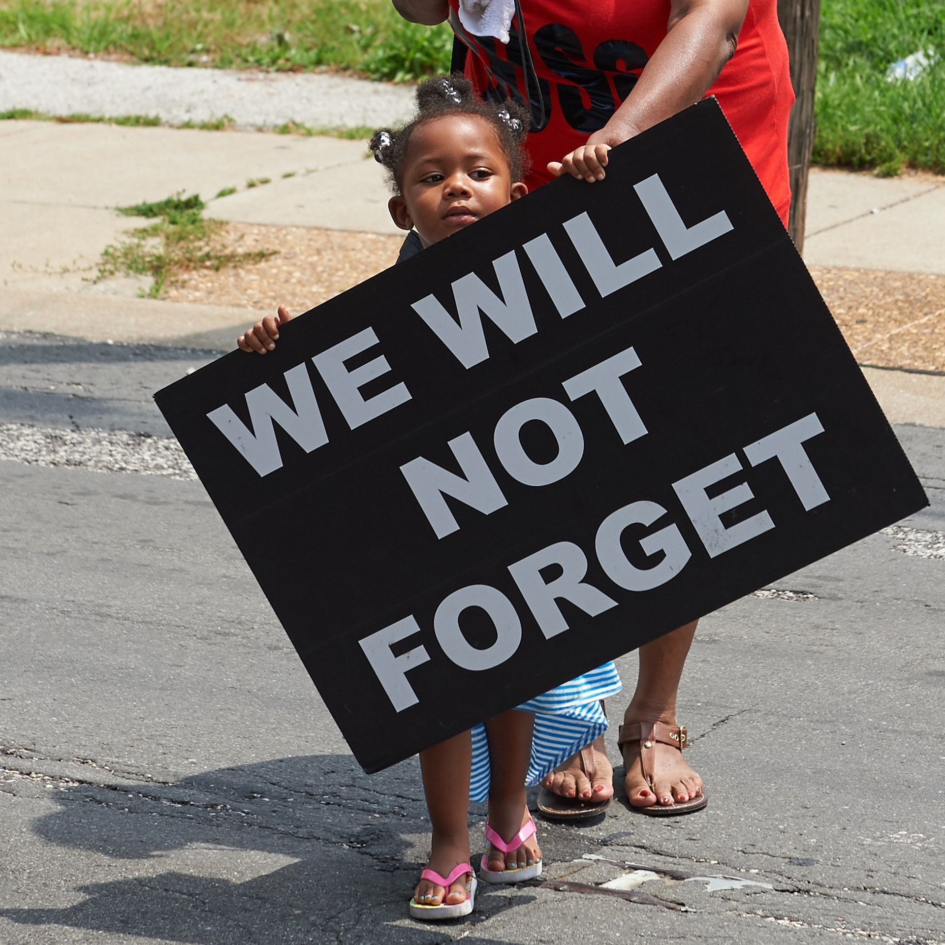 A young girl holds a sign on August 8, 2015 in Ferguson, Missouri. As the embattled community celebrates the one-year anniversary of the shooting of Michael Brown Jr. by a Ferguson police officer.