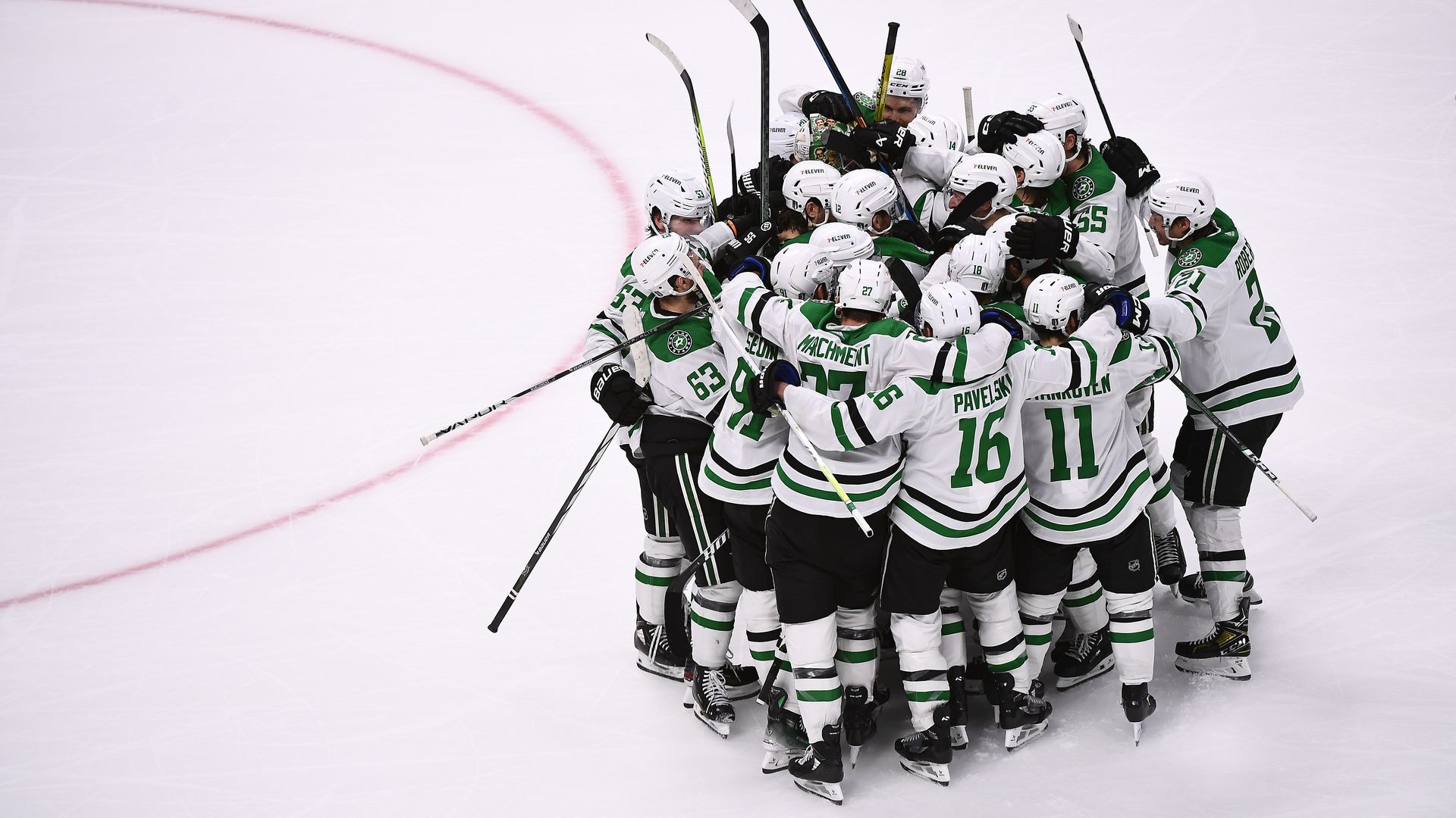 Hockey players huddled in a circle on ice