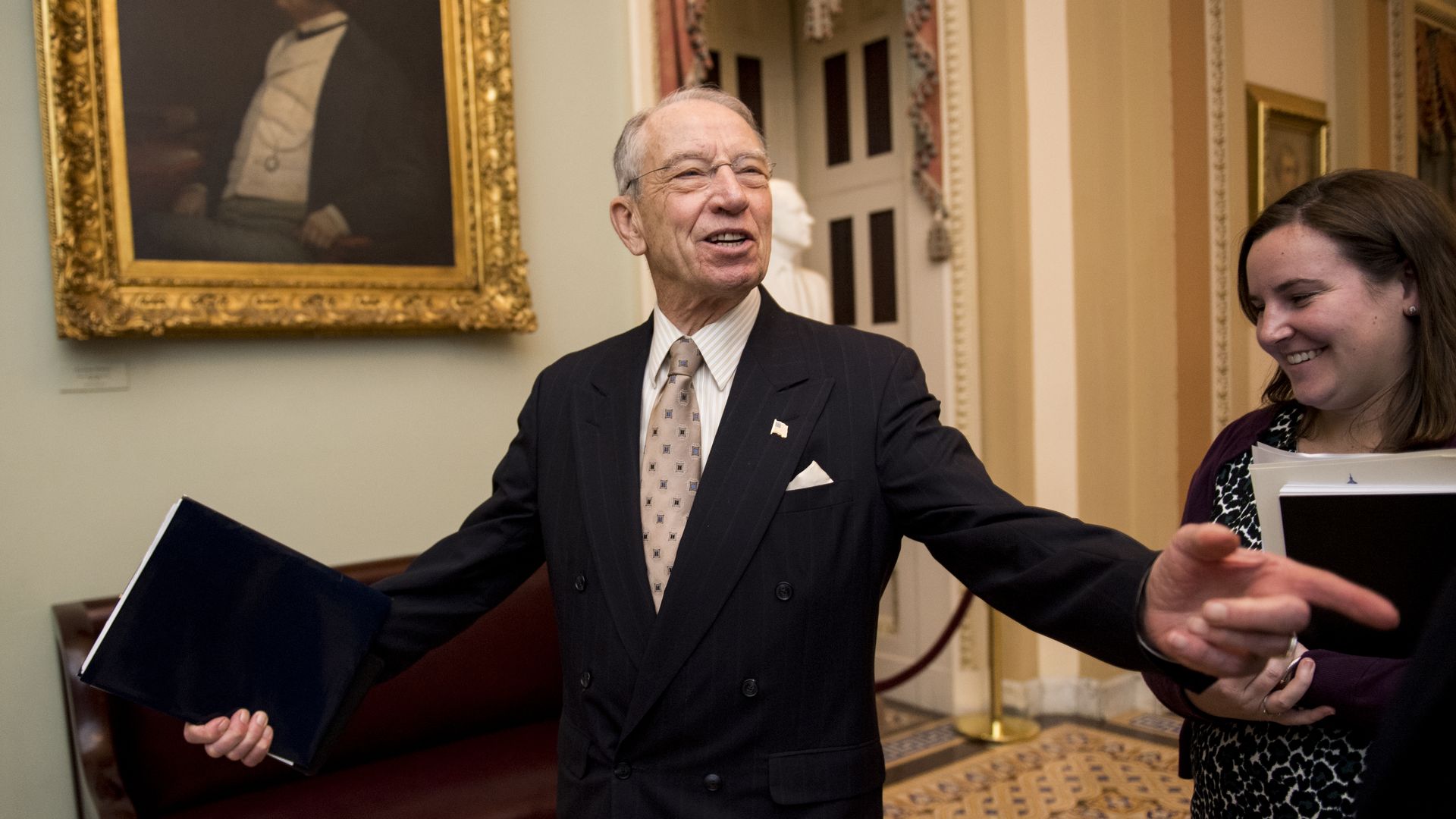Senator Chuck Grassley, wearing a suit and tie, in the middle of an interaction with someone off-screen