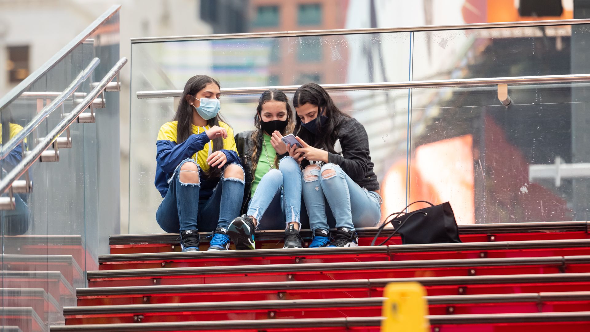 Young people looking at a phone in Times Square in New York City in October 2020.