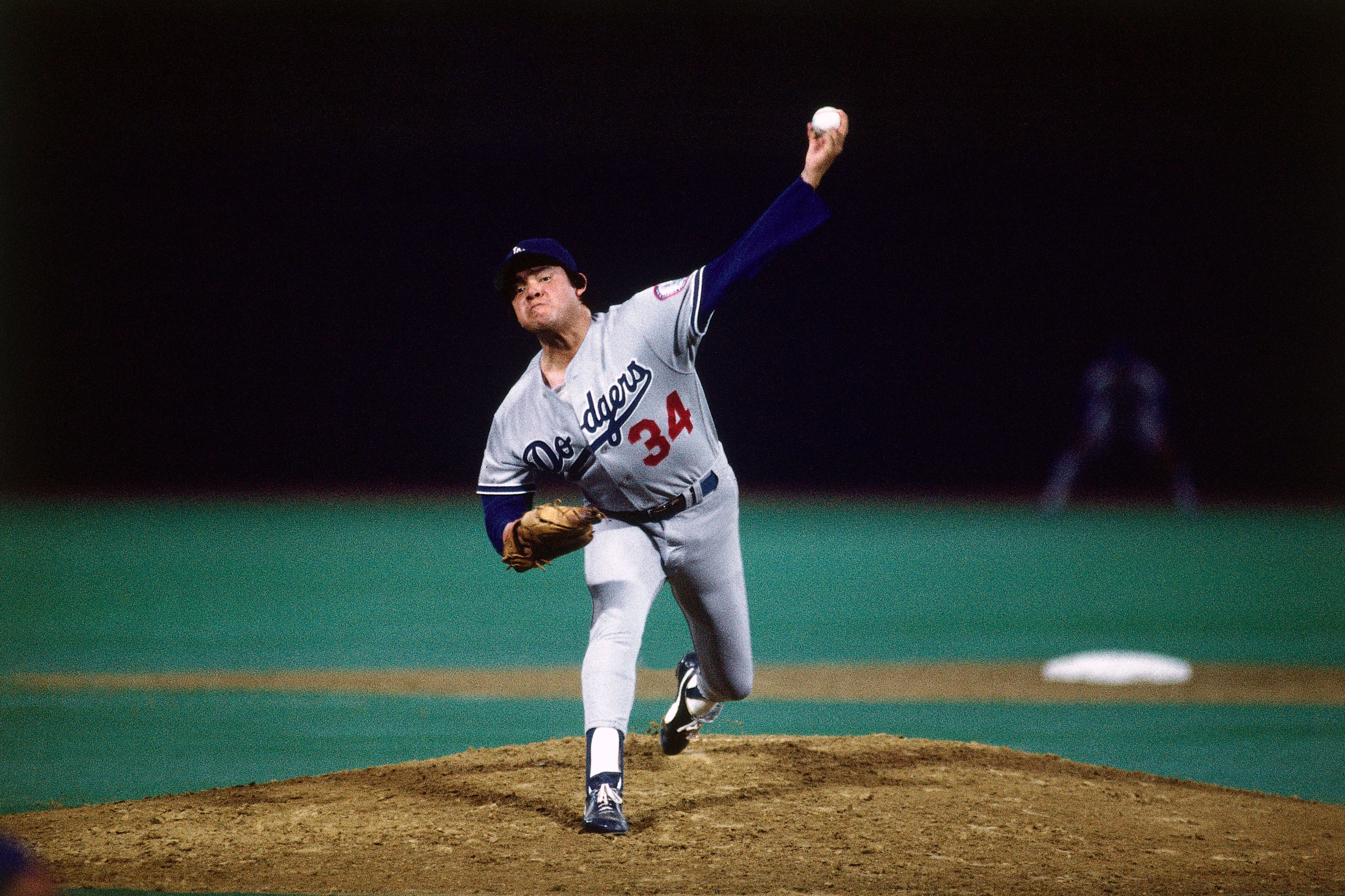 Fernando Valenzuela pitches a ball during a game while wearing the Dodgers uniform