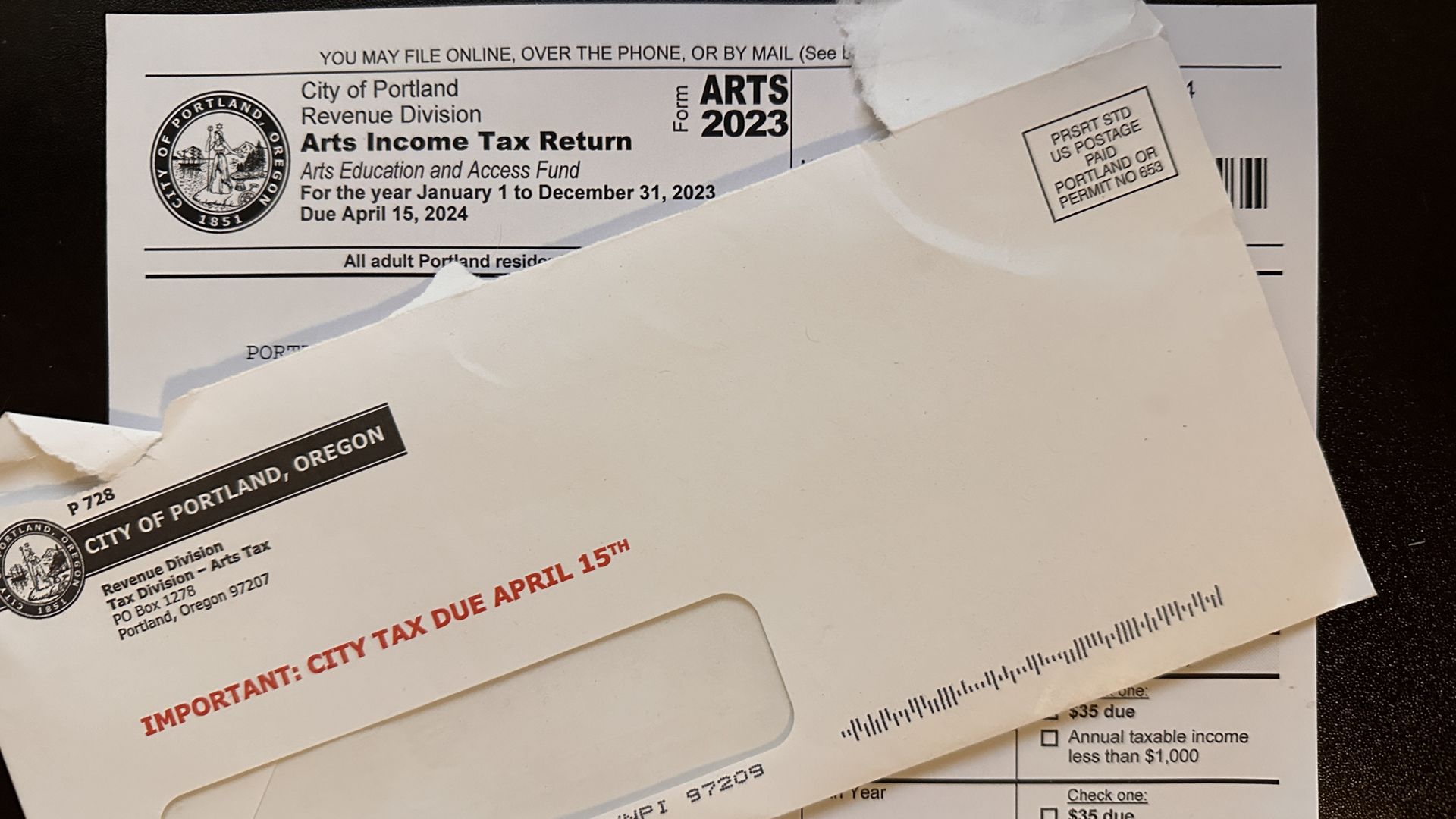 Tax form with a torn envelope on top of it