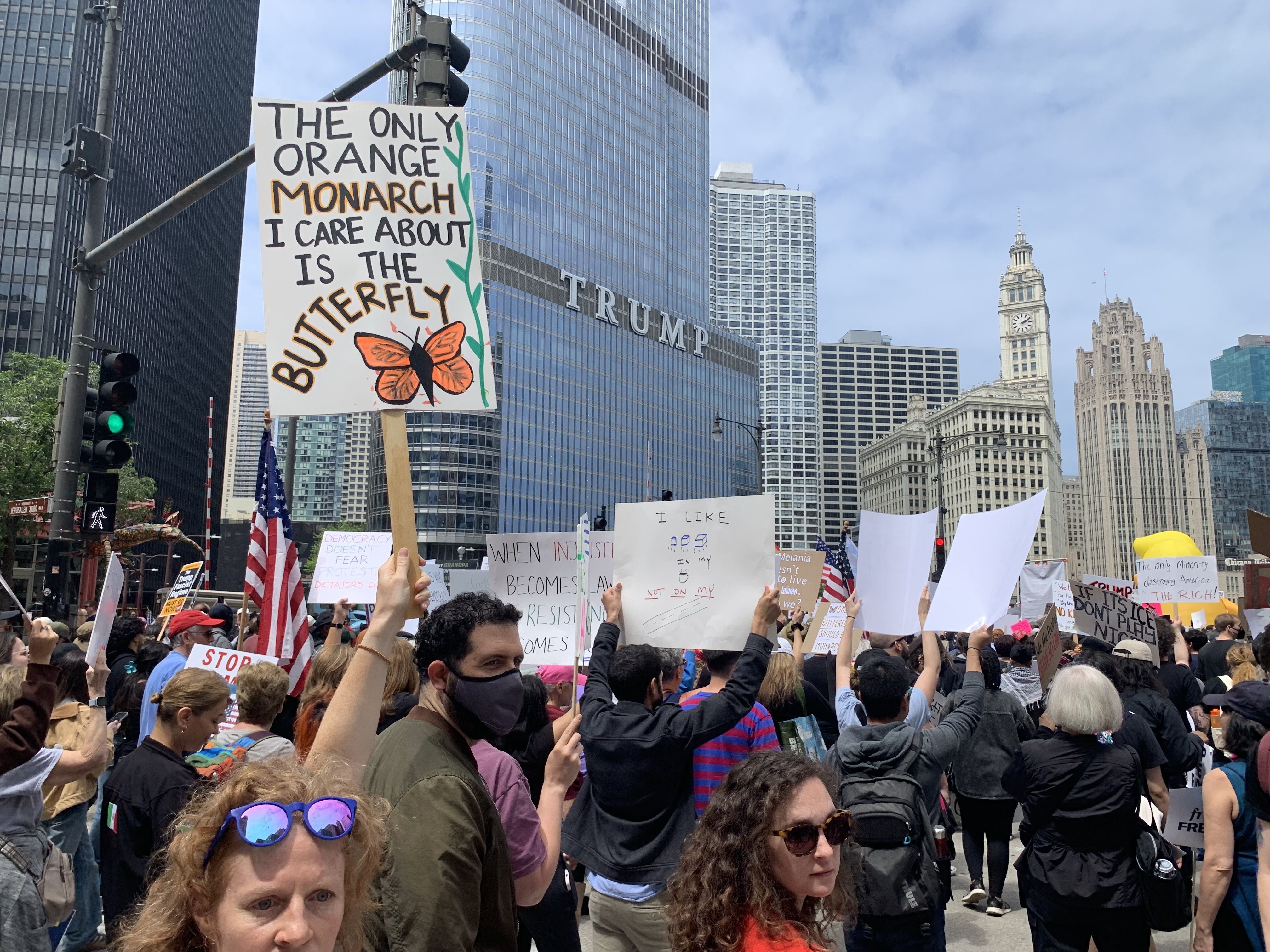 Protesters fill up a plaza with signs and march on a street. 