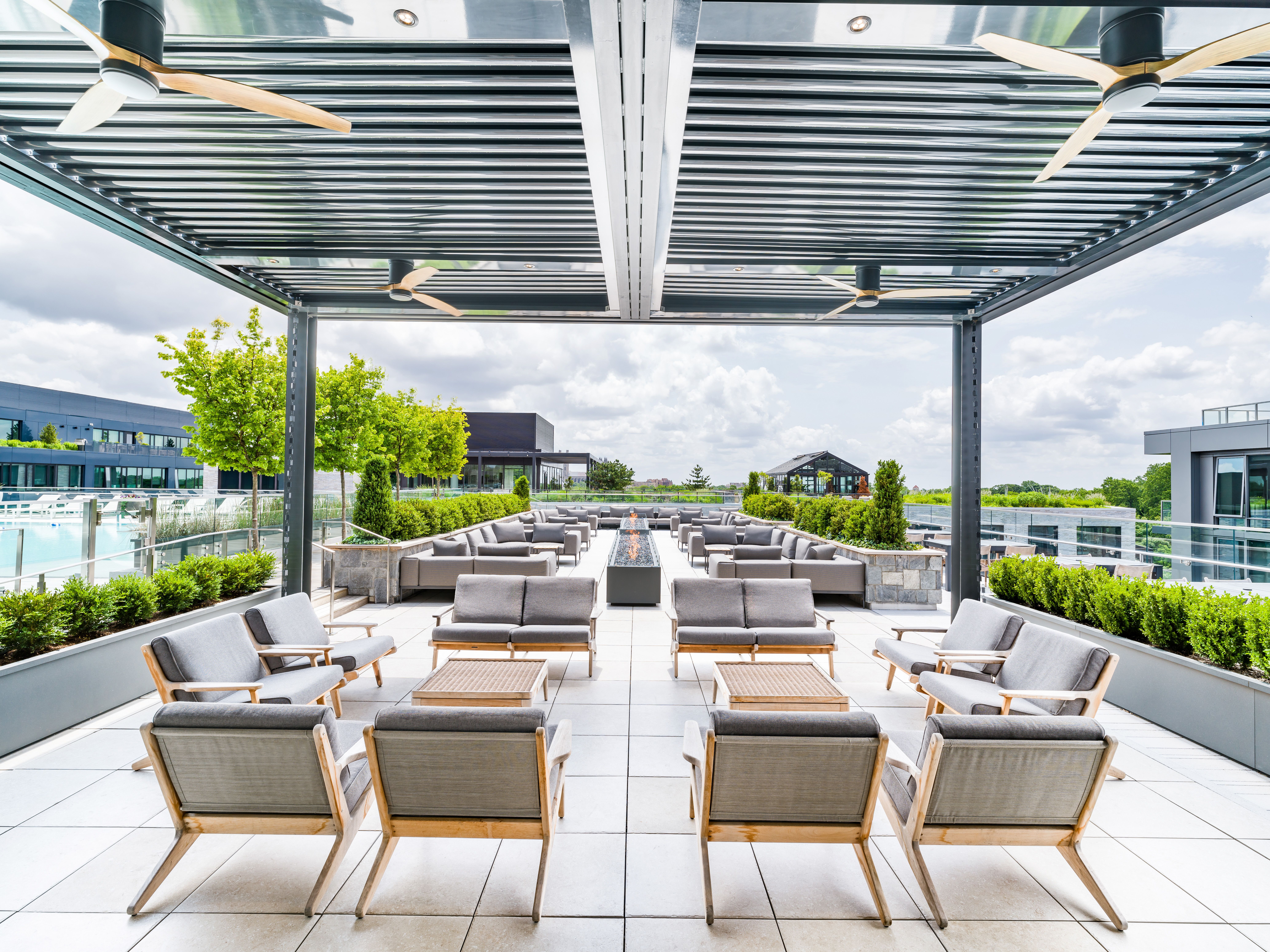 A rooftop pool lounge with sofas overlooking a pool 