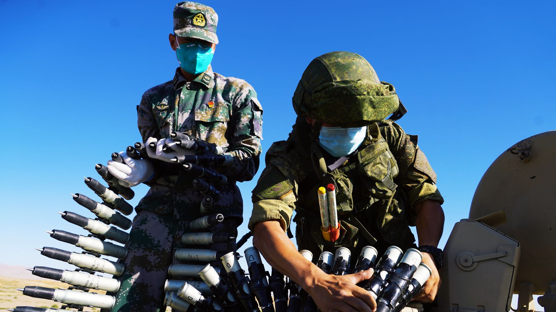 Military personnel prepare equipment for a joint military drill by the Chinese and Russian armies