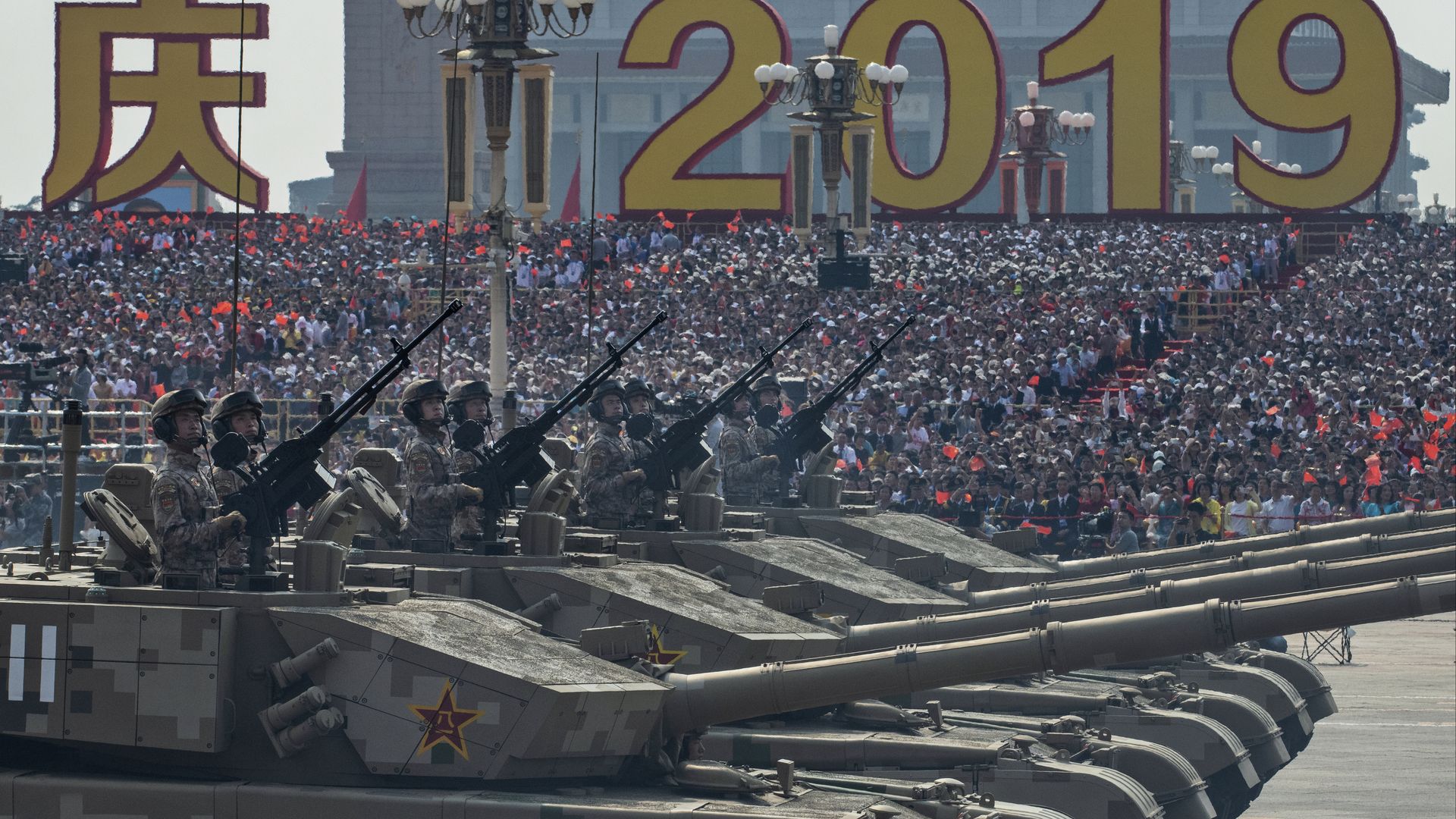 Chinese soldiers sit atop tanks as they drive in a parade to celebrate the 70th Anniversary of the founding of the People's Republic of China in 1949