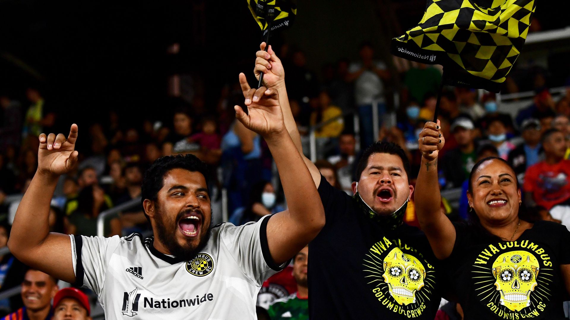 Columbus Crew fans celebrate a goal by waving flags.