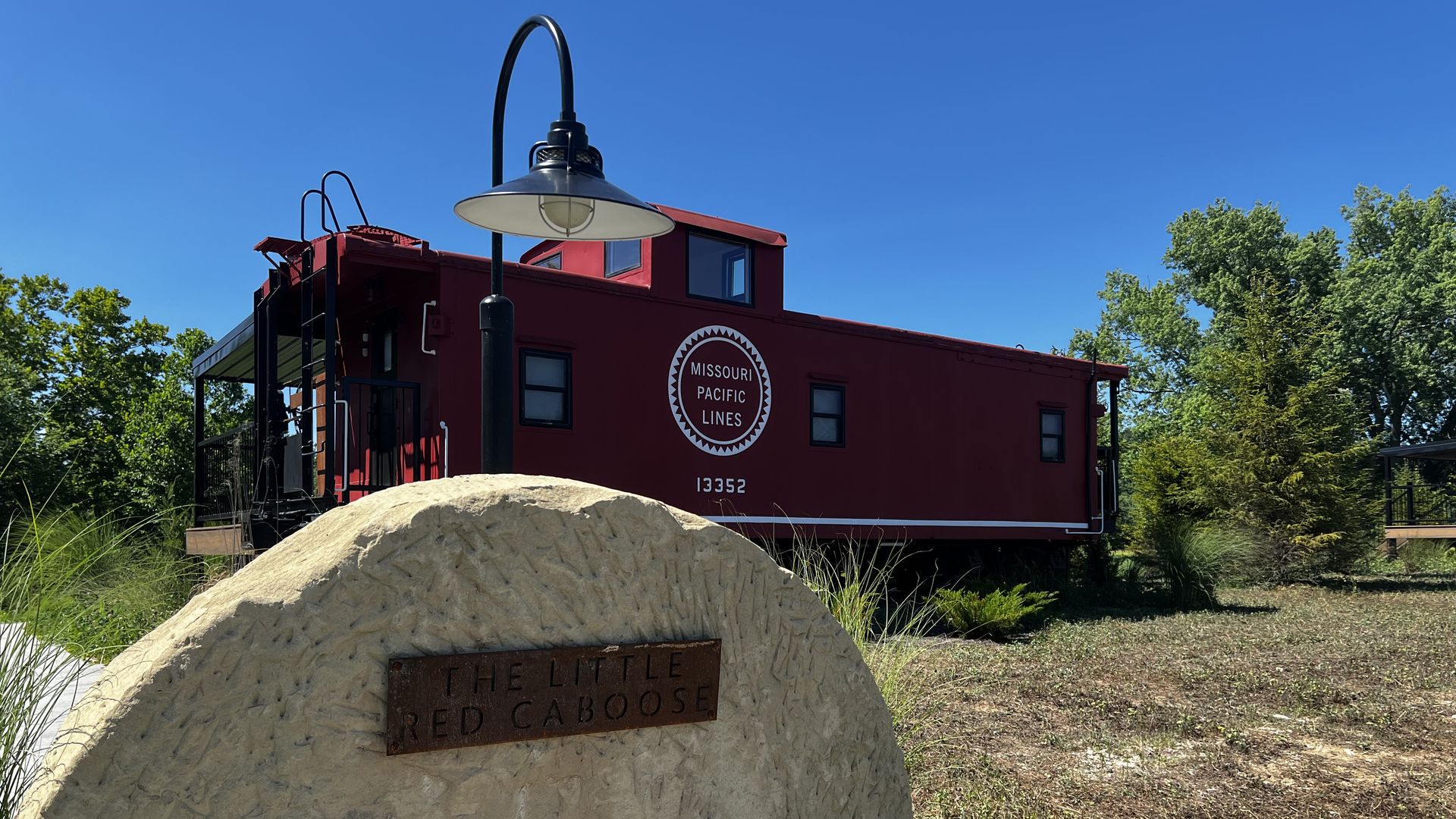 Photo of a red caboose that's been converted into a cabin. 
