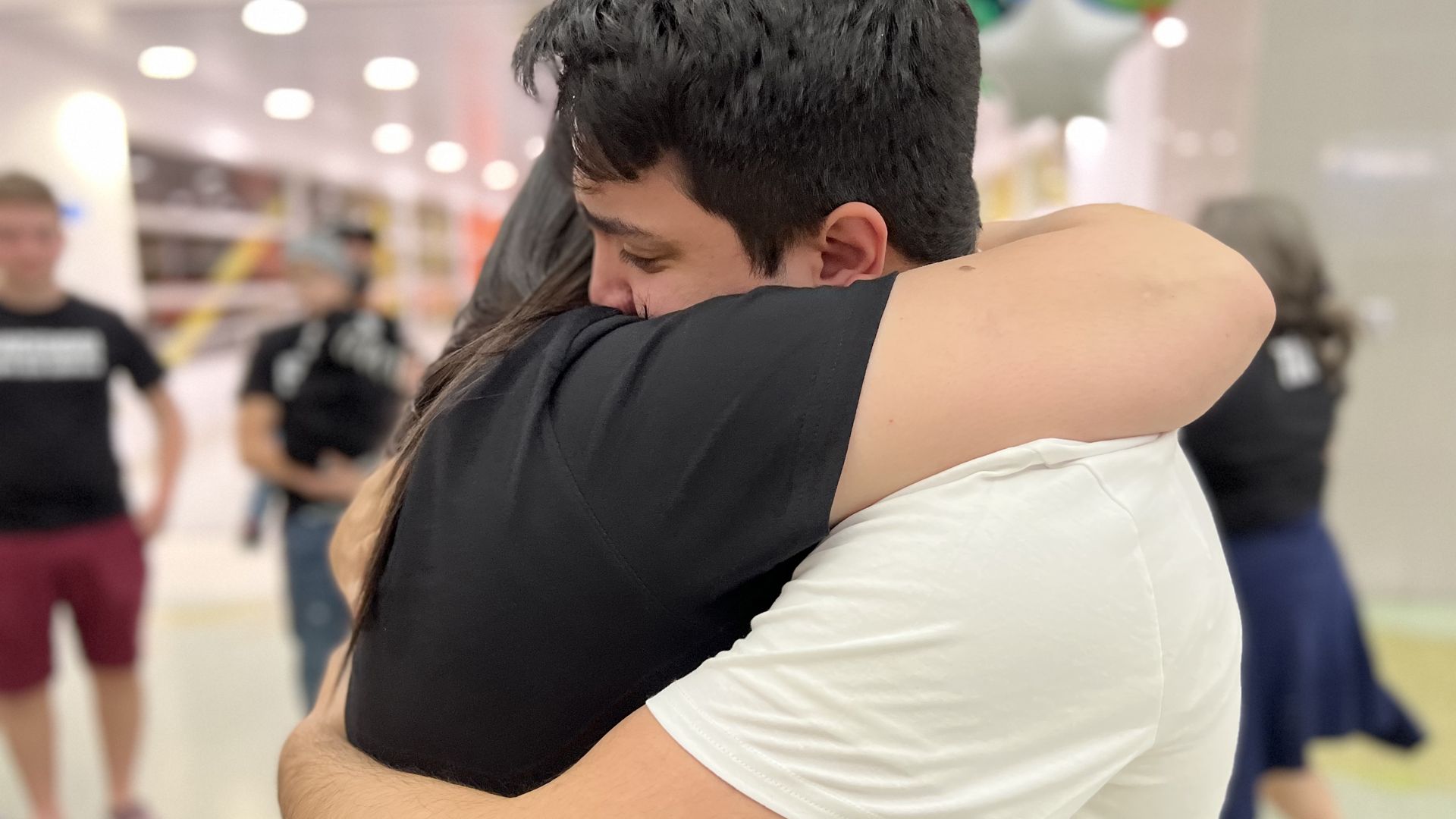 A woman and a Venezuelan man who had been deported from the U.S. embrace