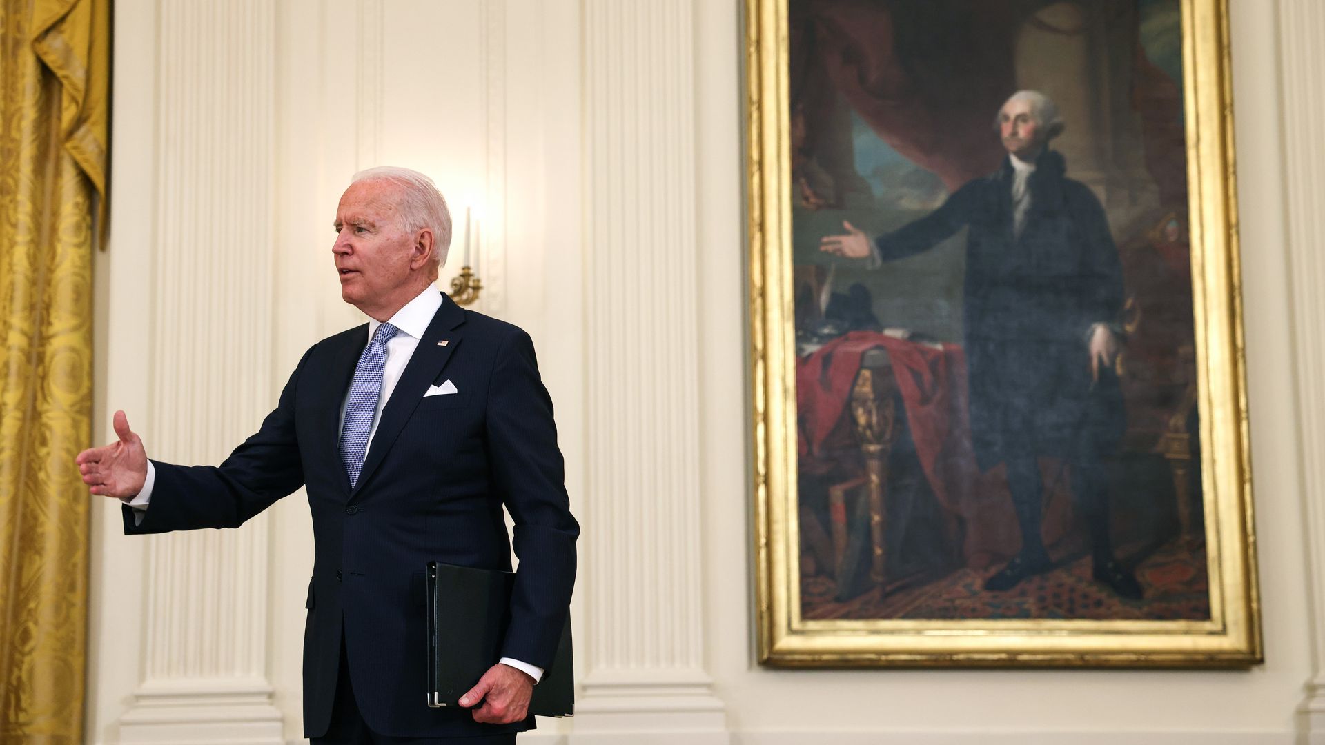 President Biden is seen mimicking the pose in a nearby portrait of George Washington.